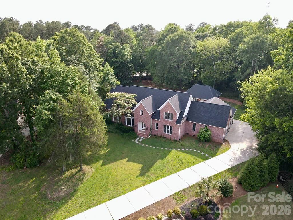 A great place to call home!  Right in the middle of Fort Mill's charming bustling neighborhood, you'll find Oxford Place East.  Located on a quiet culdesac with over an acre lot.  The yard is fenced and features an in ground pool with spa, expansive deck. screened porch and a full brick Guest House.  The main house is open and welcoming.  The entry hall is two story and showcases the staircase with balcony overlooking the first floor.  There is lots of room to roam in this 5 bedroom plan.  The owner's suite has a fireplace, spa tub and it's own covered entrance.  The cook's kitchen is just off the morning room and has upgraded cabinets for lots of storage. The upstairs has a finished bonus room, 3 more bedrooms and Jack and Jill bath.  This home has upgrade galore that must be seen to appreciate.  It is freshly painted and has new carpet in upstairs.  The Guest House was not finished but has recently  been completed and is truly comfortable with a living room, dining room, bedroom and bath.  It has it's own kitchen, laundry and porch. For a full list of upgrades and improvements is attached under associated docs.