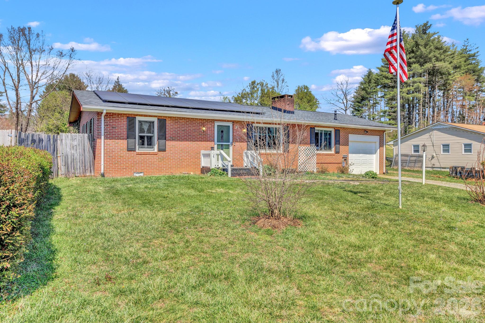 Welcome to 1195 Hendersonville Highway in Pisgah Forest, a well-maintained brick ranch in a highly convenient location just 1 mile from the entrance to Pisgah National Forest, 2 miles from Brevard, and 18 miles to both Hendersonville and the Asheville Airport.

Inside, the home features wood floors, built-in shelving, and a comfortable living room with a fireplace equipped with natural gas logs. The kitchen includes a breakfast area and connects easily to the main living space, making it functional for everyday living. The bathroom has been updated and includes a step-in tub for added accessibility. There is also a flexible additional room that can be used for guests, an office, or other needs.

Recent updates include a roof replaced approximately two years ago, two front windows replaced around six years ago, and a solar panel system to help offset energy costs. The seller has also installed approximately $13,000 worth of heat shield insulation in the attic, improving overall efficiency. Additional features include a gas (on-demand) water heater, an alarm system that conveys, a stainless refrigerator (approximately 2 years old) in the kitchen, and a second refrigerator in the mudroom.

Outside, the fenced backyard offers a great mix of usable space and functionality, complete with fruit trees and a greenhouse—ideal for gardening or hobby use. Distant mountain views add to the setting, giving you a sense of place without sacrificing convenience. Overall, this home offers a solid combination of updates, usability, and location.