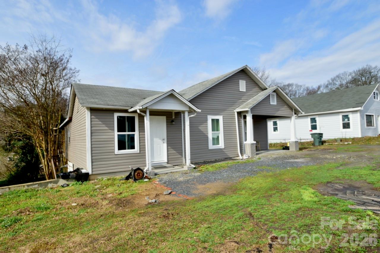 Moving to Gastonia? This freshly updated gem is ready for its next chapter! The current owner has revitalized the space with fresh paint and durable luxury vinyl plank flooring that flows seamlessly throughout the entire home.
Step inside to a spacious living room featuring a charming (decorative) closed-off fireplace—perfect for cozy vibes. The heart of the home is the massive eat-in kitchen, boasting crisp white cabinetry, classic white subway tile backsplash, and convenient laundry hookups.
The layout offers unique flexibility with two bedrooms connected in a tandem style (walk through one to reach the other). There is an additional flex room with its own private entrance directly from the massive backyard deck, making it an ideal guest suite or home office. The current owners use this space as a bedroom. Additionally, all three bathrooms have been fully renovated with new vanities, toilets, and stylish tub surrounds. Outdoor lovers will  also obsess over the oversized deck that spans the entire length of the house, overlooking a generous backyard.