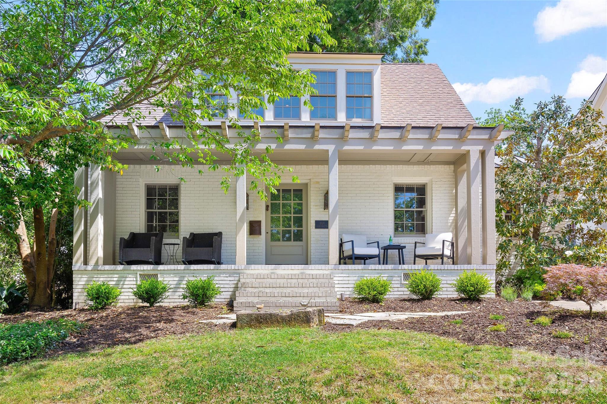 Stunning cottage nestled on a quiet street in highly desirable Myers Park. Completely renovated in 2007 by renowned architect Ruard Veltman, this home showcases exceptional craftsmanship and high-end finishes throughout.
A charming front porch welcomes you, setting the tone for the thoughtfully designed interior. The main level features newly refinished hardwood floors, extensive crown molding, and a gracious lay out ideal for both everyday living and entertaining.
The primary suite on the main level opens to a private terrace. It includes dual walk-in closets with custom upholstered doors accented with nailhead trim. The luxurious bath offers dual vanities with concrete countertops and nickel faucets, a travertine-tiled walk-in shower with bench, rain shower faucet and a separate water closet.
The inviting living room features a gas fireplace with an English fire basket and flows seamlessly into the gourmet kitchen. Designed for both function and style, the kitchen and dining area includes bluestone countertops, custom cabinetry with designer hardware, a farmhouse sink with polished nickel Rohl faucet, quilted steel backsplash, upholstered accent panel with nailhead trim, and a French Lacanche 5-burner gas cooktop with electric oven.
Also on the main level is a secondary bedroom and a versatile office that could serve as a fifth bedroom. The office includes built-in cabinetry with antique brass hardware and a concealed washer/dryer. A hall bath features a Jacuzzi tub/shower with tile surround and a vanity with concrete countertop.
Upstairs, new carpet adds comfort to a spacious family room that opens to a deck with staircase leading to the patio and backyard. Two additional bedrooms feature charming Dutch doors and share a beautifully appointed bath. One bedroom includes a built-in upholstered twin bed with a trundle while the other offers a custom fabric headboard.
The upper-level bath is a true retreat with a marble-tiled walk-in shower, Kohler soaking tub, dual vanities with concrete countertops, woven wood tile accent wall, linen closet, and a separate water closet.
Outdoor living is equally impressive with a fenced yard, copper roof over kitchen,  garden shed, new patio, deck, and staircase perfect for relaxing or entertaining. Additional features include an architectural shingle roof, home speaker system (living room, kitchen, primary suite, and outdoor areas), custom grass blinds in most rooms and new landscaping and tree trimming.  Neighborhood amenities:  Freedom Park, Greenway, Park Road Shopping Center,  Reids, cute shops and dining on Selwyn Ave.