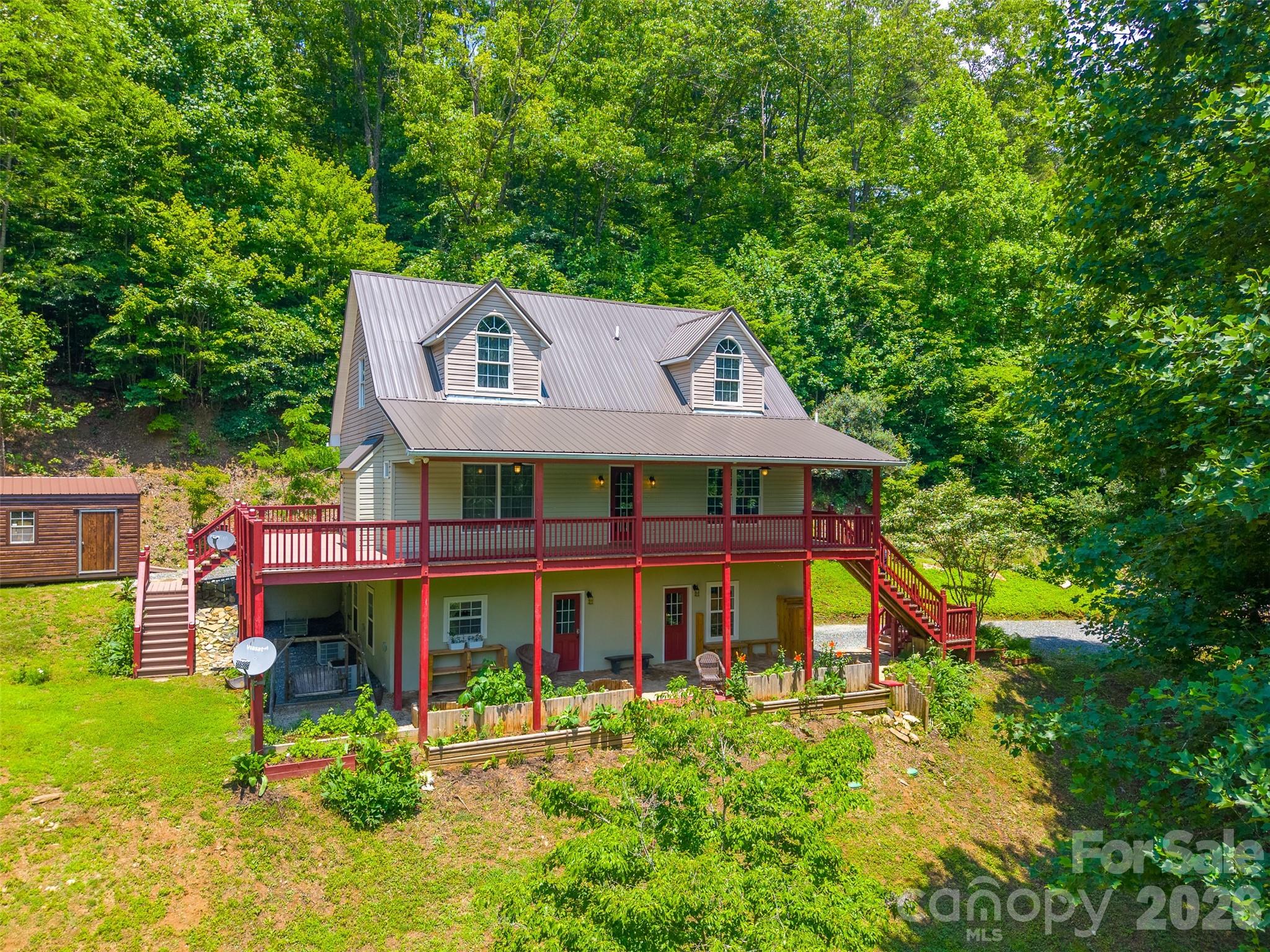 Tucked away in the mountains just minutes from downtown Bryson City, this inviting retreat offers a rare combination of privacy, natural beauty, and thoughtful updates. The property's most remarkable feature is the presence of two bold mountain creeks with mini waterfalls flowing through the property, creating an unforgettable setting filled with the soothing sounds of rushing water.

Designed for comfortable mountain living, this 3-bedroom, 4-bath home also features two versatile bonus rooms, providing flexibility for guests, a home office, hobbies, or additional sleeping space. The spacious main-level owner's suite allows for convenient one-level living, while warm hickory floors, soaring 9-foot ceilings, a propane fireplace, and granite countertops create a welcoming atmosphere throughout.

The fully finished walkout lower level features a second kitchen, full bath, additional living space with those 2 bonus rooms, garage access, and a private entrance, making it ideal for guests, multi-generational living, or rental potential.

Outside is where this property truly shines. Enjoy long-range mountain views, an expansive wraparound deck, patio spaces for gathering and relaxing, raised garden beds, a powered storage building, and more than 30 fruit trees. Whether you're gardening, listening to the creeks, or simply taking in the peaceful surroundings, the setting feels like a private mountain sanctuary.

Recent improvements include a newer roof, Bosch heat pumps with smart thermostats, smart appliances, whole-house generator, water heater, and powered outbuildings. Situated on unrestricted acreage with no HOA, this unique property is conveniently located near downtown Bryson City, the NOC, Fontana Lake, and the Great Smoky Mountains.