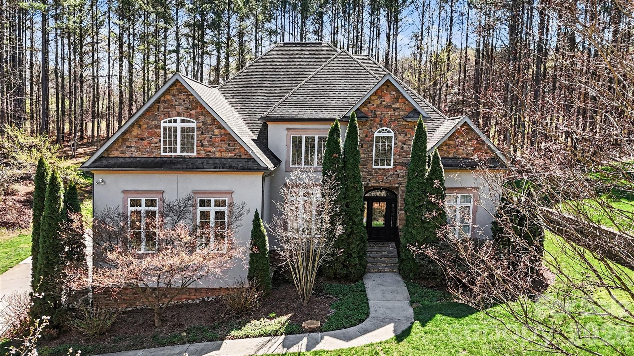 JUST REDUCED TO $775,000 — A REMARKABLE VALUE FOR THIS LUXURY ESTATE IN Winding Forest! Sellers are highly motivated and have just approved an aggressive new price improvement, creating an exceptional opportunity to own a beautifully crafted custom home on 1.35 private wooded acres near Lake Norman. Homes offering this level of privacy, space, quality, and location are rarely available at this price point.

Nestled among mature trees in one of the area's most desirable and picturesque communities, this stunning two-story estate blends timeless elegance with comfortable everyday living. Every home in Winding Forest is uniquely designed, creating a custom luxury feel throughout the neighborhood with rolling topography, spacious homesites,  community pool amenities as well as storage available for trailers, RVs, watercraft.

Inside, you are welcomed by soaring ceilings, abundant natural light, and upscale custom finishes throughout. The dramatic two-story great room with gas fireplace creates the perfect gathering space for entertaining or relaxing. The main-level primary suite is truly impressive, offering a luxurious retreat complete with soaring ceilings, spa-inspired bath, and expansive walk-in closet space that must be seen in person to fully appreciate.

The chef’s kitchen features stainless steel appliances, extensive cabinetry, center island, breakfast bar, pantry, and seamless flow into both formal and casual dining areas. Main-level laundry adds everyday convenience.

Upstairs offers an ideal layout with spacious secondary bedrooms, including a Jack-and-Jill bath, private ensuite bedroom, flex room perfect for a media room, office, gym, or playroom, plus additional storage space rarely found in today’s homes. A side-load three-car garage further enhances the home's functionality and curb appeal.

Step outside to enjoy peaceful mornings or evening gatherings from the rear porch overlooking your own serene, tree-lined backyard sanctuary. Located just minutes from Skippers Landing Safe Harbor Marina, shopping, dining, and major commuter routes, this home offers the perfect balance of privacy and convenience.

This home truly represents one of the best luxury values currently available in the Lake Norman area. Schedule your private showing today before this opportunity is gone. Preferred lender is offering lender credits!