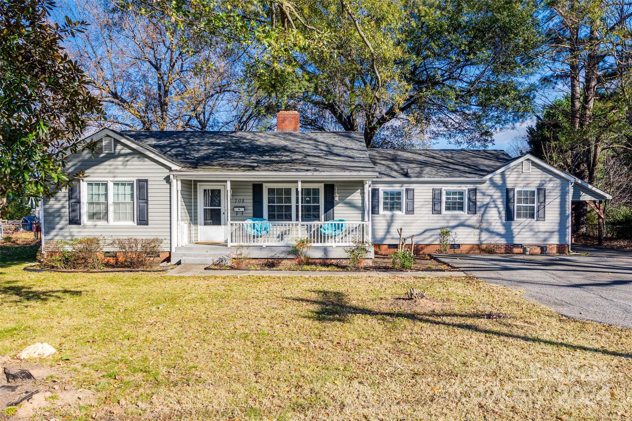 Start your mornings or unwind in the evenings on the rocking chair front porch of this delightful one-story ranch. Move-in ready, this home features 4 bedrooms, 2 full bathrooms, and plenty of space to enjoy. The kitchen has solid surface counter tops with subway tile backsplash. Stainless steel appliances including refrigerator complete the galley kitchen. You'll love the character of the original hardwood flooring throughout. Step outside to enjoy the view of the backyard from your large back deck, perfect for entertaining or relaxing. The fenced-in yard, wired shed, and side carport with extra parking (and bonus storage above) add plenty of convenience. Centrally located, this home is just minutes from all that Lowell has to offer, with easy access to nearby McAdenville, Cramerton, and downtown Belmont. Commuting is a breeze with quick access to I-85.