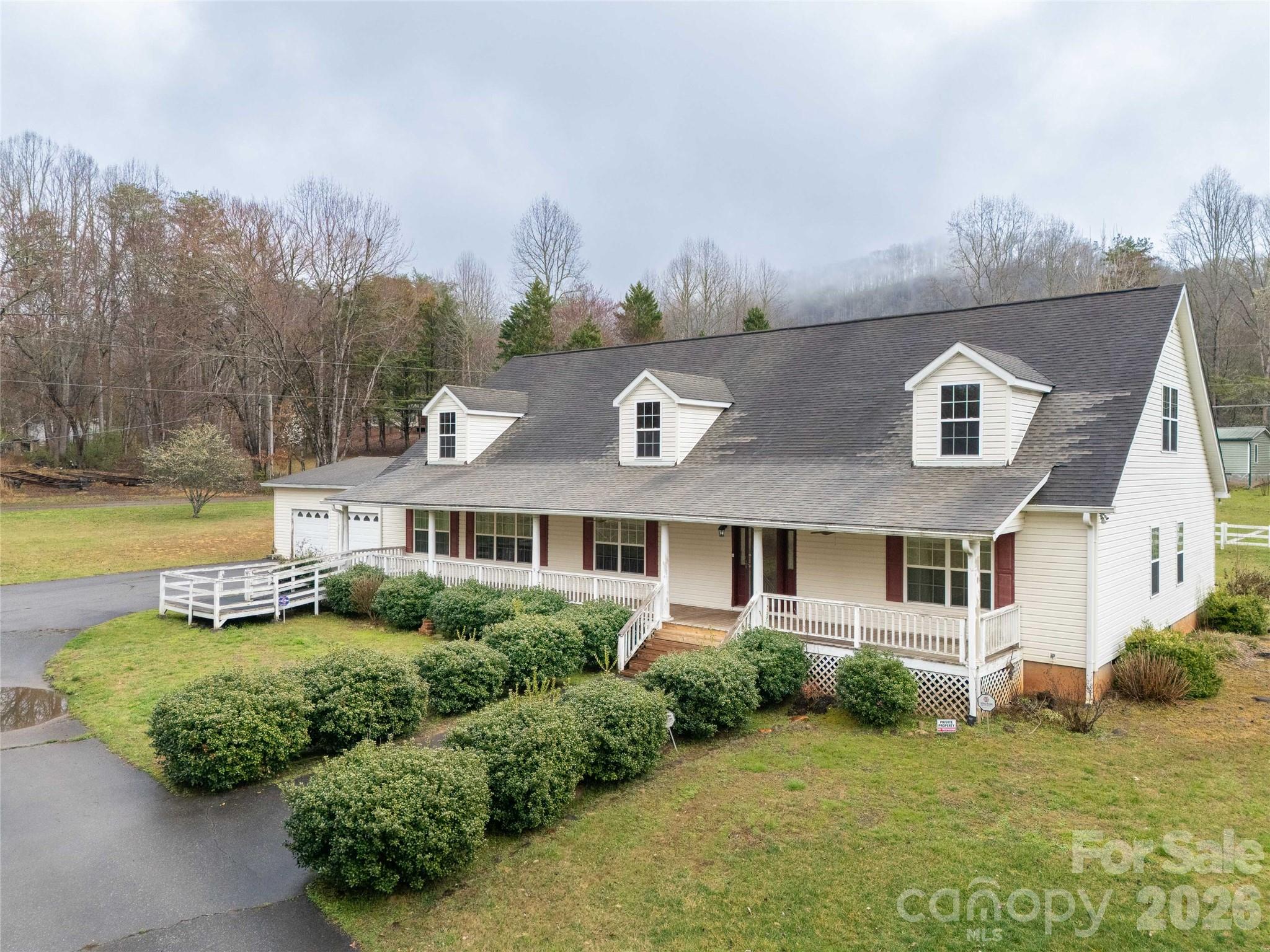 HUGE one level home on two, flat, usable, unrestricted acres in a great location. Centrally located between Sylva, Cherokee, and Bryson City in the desirable Camp Creek neighborhood. Large primary bedroom with a huge walk-in closet. Another of the three bedrooms has a bathroom of its own, with a fourth room serving as an office or flex room. There is an oversized two-car attached garage and over 2000 square feet of floored, wired, attic space. Two large areas for entertaining, separated by the kitchen and formal dining room. Enjoy a large covered front porch and two storage sheds, along with a gazebo in the yard. Paved driveway off the state road!