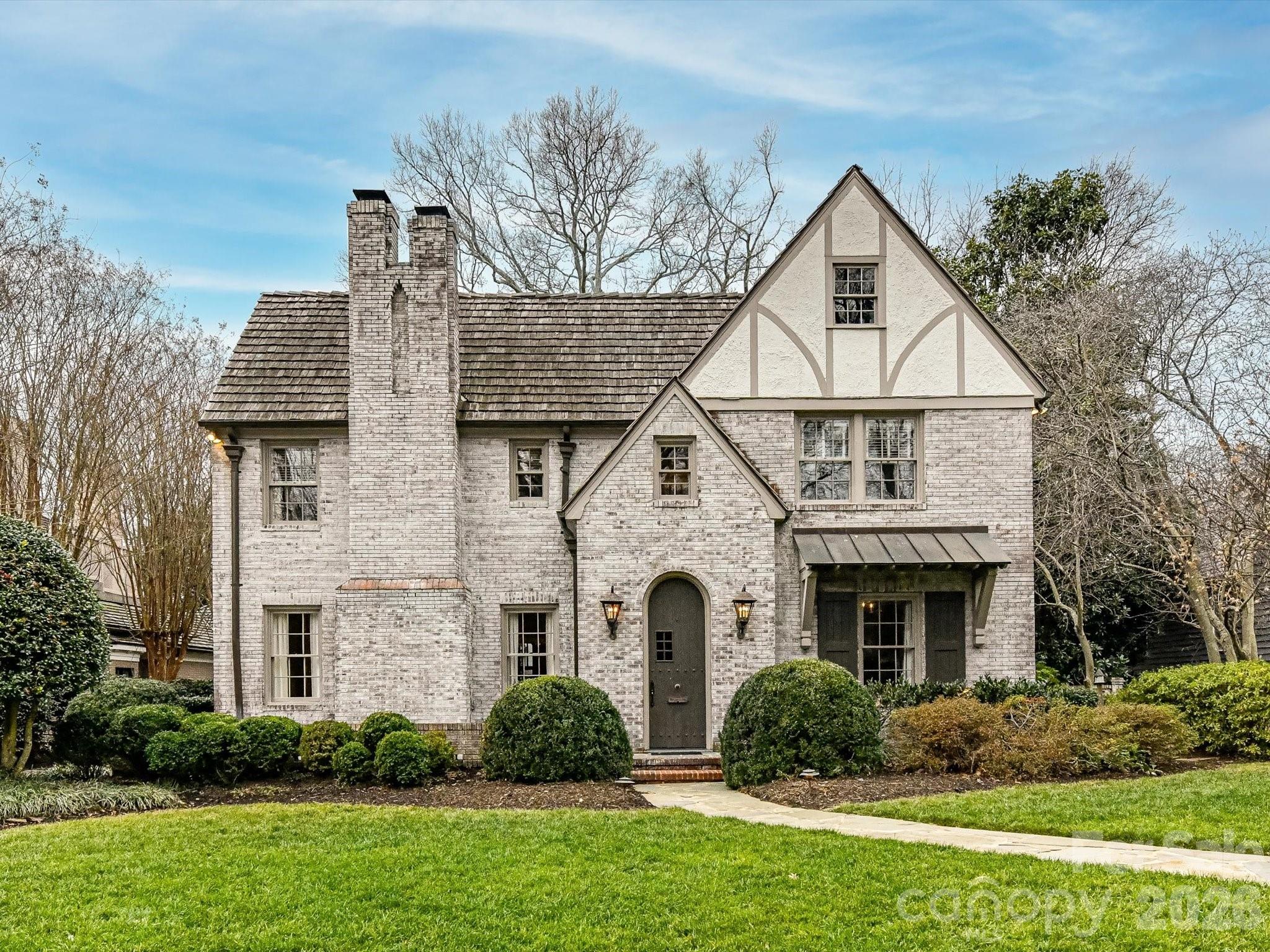 Located on the highly sought-after Queens Road West, this lovely Tudor home is beautifully updated for modern living while preserving all the best of days gone by.   The thoughtful layout makes for elegant entertaining, (the dining room!) while still finding the quiet moments.  Built-ins and bookshelves for the book lovers, create layers of design.   At the heart, is the gorgeous updated chef's kitchen with its oversized island meant for gathering, and a step away from the window-lined great-room with views to the lush private yard.  Upstairs, each of the 4 bedrooms has its own en-suite bath, deep closets and generous dimensions.  The upstairs laundry room & the downstairs mud rooms are loaded with storage, oversized sinks and room to maneuver.  And of course, the garage apartment -- complete with kitchenette & full bath, is the loveliest of guest retreats (or office or work-out studio?)   Serene and private, this beautiful 1936 home is a homage to lawn parties and cocktails by the fire, but easily manages homework at the kitchen table.  Come and see.