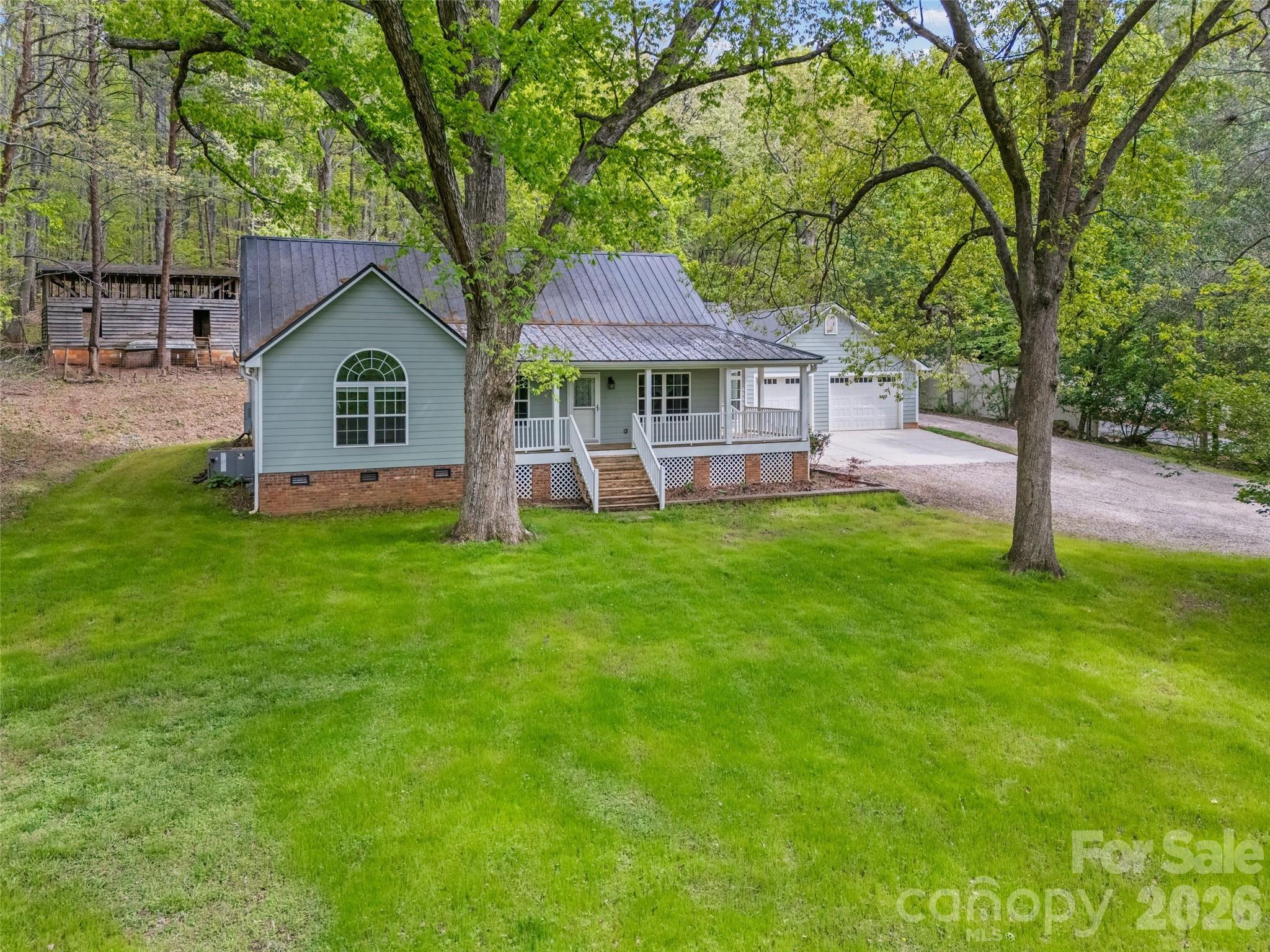 Tucked Away Treasure with Room to Roam! Welcome to your own slice of peaceful paradise tucked in the woods with the privacy you’ve been dreaming of and NO HOA to hold you back! This charming updated ranch is perfect for those craving space, freedom, and a little adventure. Whether you’re looking to build your dream micro farm, host unforgettable gatherings, or simply unwind on your rocking chair front porch, this property delivers. Love the outdoors? You’re at the foot of Nanny’s Mountain where hiking is at your doorstep. It's a local favorite with breathtaking views! Inside, you’ll find: An adorable updated home (new kitchen and baths, fresh paint, new flooring throughout) This one level home is designed for comfort and perfect for everyday living. Outside, the possibilities are endless: Huge garage ideal for recreation vehicles, cars, or your dream workshop, Detached building ready to become a barn for chickens, goats, or hobby space. Plenty of room to create your own private retreat. Conveniently located near Clover schools and just a short drive to everything Lake Wylie has to offer (shopping, dining, and lake life fun)! If you’ve been searching for a property that blends privacy, personality, and potential… this is it. Come experience the freedom to live how you want!