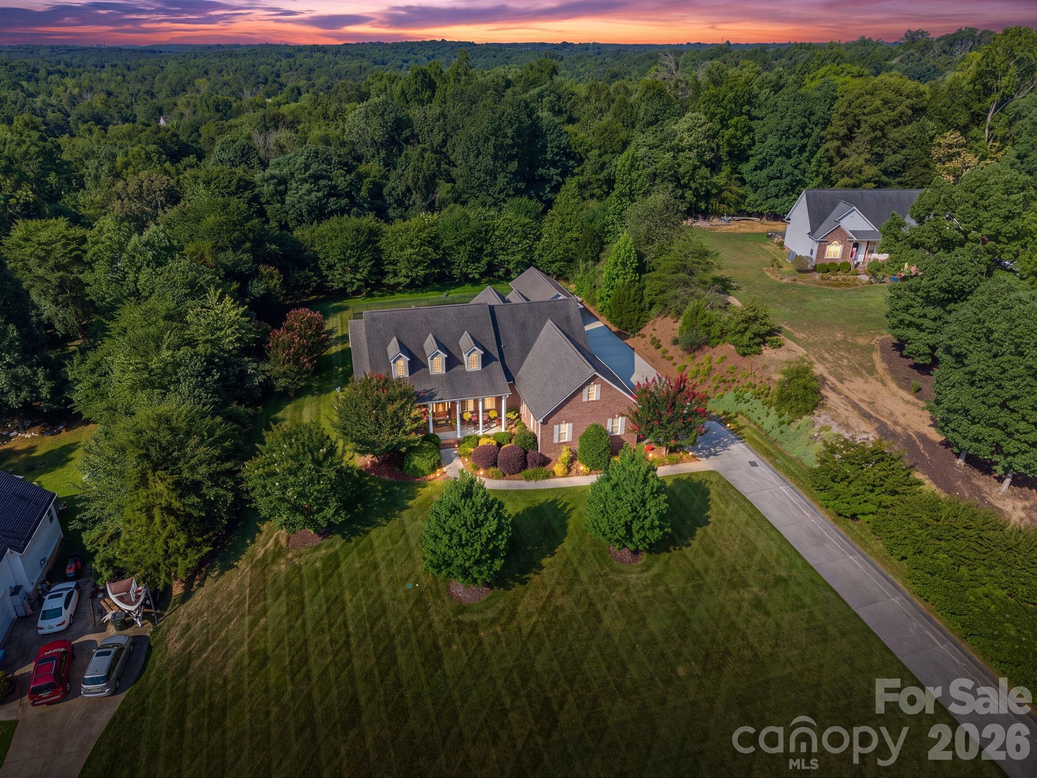 From the moment you arrive, you’ll appreciate this home’s outstanding curb appeal as it sits gracefully atop a gentle hill with a relaxing front veranda overlooking the expansive front yard. The private backyard is equally impressive, featuring mature landscaping, a large fenced area, a sunroom, and an expansive Trex deck complete with a hot tub—creating the perfect outdoor retreat for entertaining or unwinding in complete privacy. Inside the home is filled with natural light, the spacious open-concept floor plan that showcases beautiful hardwood floors throughout much of the main living areas, tall ceilings, and two inviting fireplaces that create warm, welcoming spaces for everyday living and entertaining. Boasting 3,524 sq ft, this thoughtfully designed home features 4 bedrooms plus a versatile bonus/bed room, 3 full baths, 1 half bath, and a split-bedroom floor plan that provides both privacy and functionality. The main level includes 3 bedrooms, while the expansive upper level creates the perfect private retreat or multi-generational living space with an additional bedroom, full bath, living area, and bonus room that can easily serve as a home office, media room, relaxation room or 5th bedroom. A detached garage adds more flexibility and is currently configured as a home gym with an adjoining heated/cooled office/man cave but could easily function as a workshop, hobby space, studio, etc. Additional premium features include entire yard irrigation system, solar panels to help reduce energy costs, private well water, a water softening system, reverse osmosis water filtration, walk-in attic storage and numerous additional updates and improvements over the last several years that reflect the pride of ownership throughout (see list). This is more than just a home—it’s a lifestyle that offers space, privacy, versatility, outstanding amenities and located in one of Clover’s most desirable neighborhoods and within the brand new Lake Wylie High School district.  961 Colleton Meadow Drive is a rare opportunity to own a truly special property.