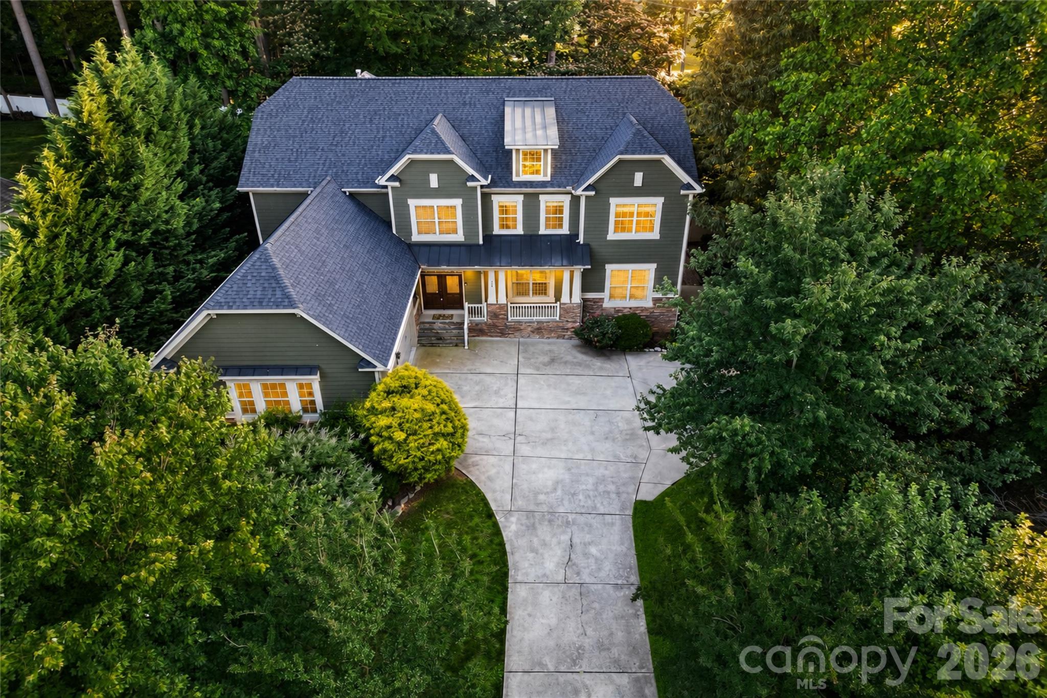 Rarely does a property offer this much space, privacy, and Lake Norman lifestyle access without the premium waterfront price tag.

Situated on a private 0.55-acre corner lot surrounded by mature trees, this impressive 5-bedroom home combines beautiful water views, nearly 4,900 square feet of living space, and a flexible floor plan designed for both everyday comfort and large-scale entertaining. Located just minutes from Mooresville's shopping, dining, marinas, and lake access, the property offers the lifestyle buyers seek while maintaining the privacy and tranquility that are increasingly difficult to find.

Inside, warm wood flooring and a flowing layout connect multiple living, dining, and gathering spaces throughout the home. The spacious kitchen features granite countertops, abundant cabinetry, a center island, walk-in pantry, and seamless access to the surrounding living areas, creating an ideal setting for both daily living and entertaining.

One of the home's standout features is the oversized recreation room, offering exceptional flexibility for a media room, game room, second family room, home office, fitness space, or multi-generational living. With direct access to a private balcony overlooking the backyard, it creates a unique indoor-outdoor retreat rarely found in homes of this caliber.

The main-level primary suite provides convenience and privacy, complete with dual vanities, a soaking tub, walk-in shower, and spacious walk-in closet. Upstairs, an expansive loft offers yet another versatile living space, providing room for growing families, guests, hobbies, or work-from-home flexibility.

The outdoor living experience is equally impressive. Designed for both relaxation and entertaining, the fenced backyard features a fire pit gathering area, pond water feature, open lawn, mature landscaping, and multiple spaces to enjoy the peaceful surroundings. Sunset views and glimpses of Lake Norman create a setting that feels both private and connected to the lake lifestyle that makes this area so desirable.

Additional highlights include a three-car side-load garage, paved driveway, no HOA, and a roof replaced in April 2025 with a transferable warranty.

Opportunities combining nearly 4,900 square feet, water views, exceptional privacy, a main-level primary suite, three-car garage, and convenient access to Lake Norman amenities are increasingly rare. This home delivers the space, flexibility, and lifestyle today's buyers are searching for without compromise.