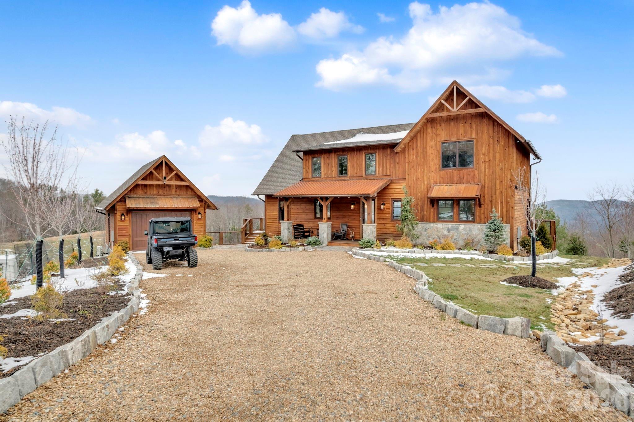 Nestled at the end of a quiet cul-de-sac in The Lodges at Eagles Nest, this beautifully crafted 4-bedroom, 4-bath mountain retreat offers privacy, long-range views, and exceptional quality on nearly 3 acres. Designed for both comfort and entertaining, the home features vaulted ceilings, wide plank hickory flooring, and a dramatic stone fireplace extending to the ceiling in the great room, creating a warm and inviting mountain atmosphere.

The spacious kitchen is appointed with quartz countertops, upgraded appliances, farm sink, beverage bar with refrigerator and ice maker, and designer backsplash, making it ideal for hosting gatherings. A convenient mudroom entrance between the home and detached garage adds functionality for mountain living.

Step outside to experience the true highlight of the property—expansive covered decks with a stone gas log fireplace overlooking sweeping long-range mountain views. Just below, a beautifully constructed stone fire pit patio creates the perfect setting for evening conversations under the stars.

The detached garage is fully insulated and climate controlled with its own mini-split heating and cooling system, ain industrial sink with hot and cold water, and separate electric service, offering exceptional flexibility for storage, workshop space, or future conversion to additional living space. The home also features a 40kW liquid cooled whole-house Generac generator, radon mitigation system, upgraded insulation, and extensive structural enhancements for durability and efficiency.

Additional highlights include level entry access, upgraded lighting, structured wiring, remote controlled retractable roller shades, and premium finishes throughout.

Located within the highly sought-after Lodges at Eagles Nest community, residents enjoy access to world-class amenities including hiking and ATV trails, winery, fitness center, sports courts, and outdoor recreation areas.

A rare opportunity to own a private, luxury mountain retreat with incredible views and exceptional upgrades in one of Banner Elk’s premier communities.