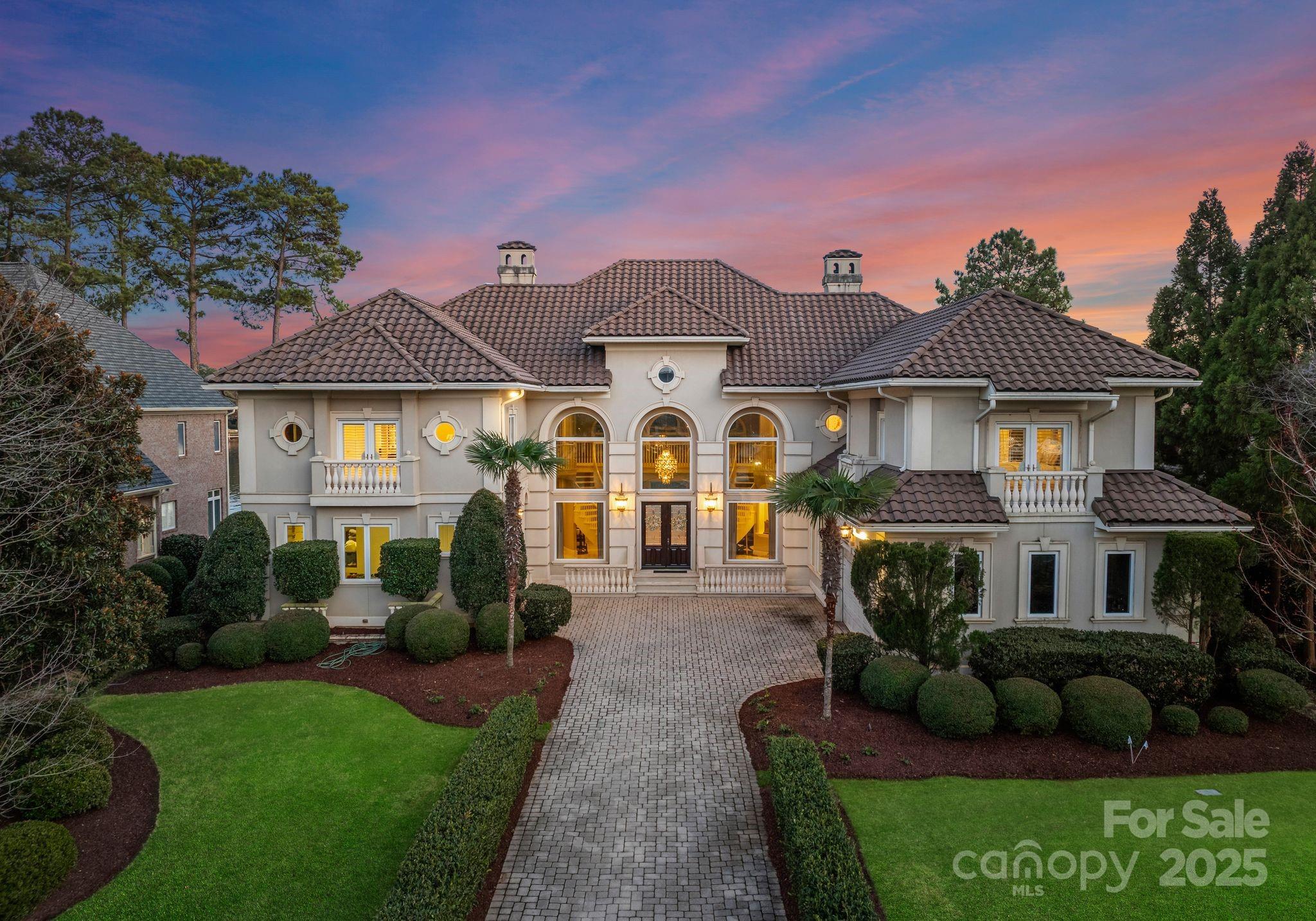 Nestled in the esteemed Peninsula community, directly across from the Yacht Club, this grand estate is the epitome of timeless elegance. Set on the tranquil shores of Lake Norman, the home features multiple fireplaces, including a stunning double-sided design in the great room. The expansive master suite serves as a serene retreat, with a lavish ensuite to match. The gourmet kitchen, second kitchen, and open-concept living areas are tailored for refined entertaining. A wine room, theater, sauna, & gym complete the home's offerings. Outdoors, the covered sitting area along the gangway invites leisurely lakeside moments, while the outdoor grilling area, firepit, & two pergolas enhance the space for gatherings. A saltwater pool and spa provide an inviting oasis. With an elevator, exquisite finishes, and sweeping lake views, this residence is a rare gem for those who appreciate the finest in sophisticated living. Offered fully furnished with select exclusions—see attachments for details.