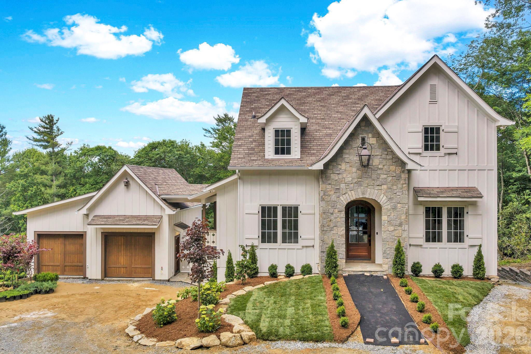 The Cottage at Old Boone - NEW CONSTRUCTION near Downtown Blowing Rock! Just a short golf cart ride away from Main Street, this brand new 2026 build brings together a bright and airy, contemporary design and tasteful mountain touches to offer a gorgeous home in a great location! Year-round access on easy-to-travel roads makes this property suitable as a full time residence or perfect for a mountain getaway that’s close to shopping, dining, ski slopes, and all the nearby National Parks and trails off the Blue Ridge Parkway. With 3BR 3.5BA, living spaces are centered around an open kitchen (with stainless steel Thermador appliances) and great room, with dual sided stone fireplace that can also be enjoyed from the adjacent back deck! A private Primary Suite on the walk in level offers a luxurious bath with soaking tub and separate tiled shower while two more bedroom bathroom suites and a 2nd living room with wet-bar are located upstairs. A dining/office/flex room, walk-in pantry, main level half bath, laundry on BOTH floors, detached 2 car garage, covered front entry, and lower golf cart storage provide ample options for layout and use. No detail was spared in construction: solid oak wood glass doors at garage and entry, prewired for EV charger, epoxied garage floor with drains and smart board exterior siding used inside for ability to wash vehicles (plus heater with thermostat), custom gas lanterns by St. James Lighting Company, keyless entry. Fireplace mantels and floating wood shelves over main level bar were reclaimed from historic Green Park Inn (over 150 years old!)! Trex decking, exposed beams, Kohler and Kingston Brass faucets, water purification system at kitchen sink, heated bathroom floors, high and low bedroom tv mount options (for hidden wiring), vaulted tongue and groove ceilings, Rockwool interior wall insulation for noise reduction, engineered wood floors. 3 HVAC zones with dehumidification, humidification, and air purification systems installed. Weather-sealed glass doors on exterior fireplace, natural/real stone on exterior, GAF Presidential series shake roof. Pre-wired for full house generator. THE LIST GOES ON AND ON! Design by Molly Northern Interiors! C/O expected July 2026!