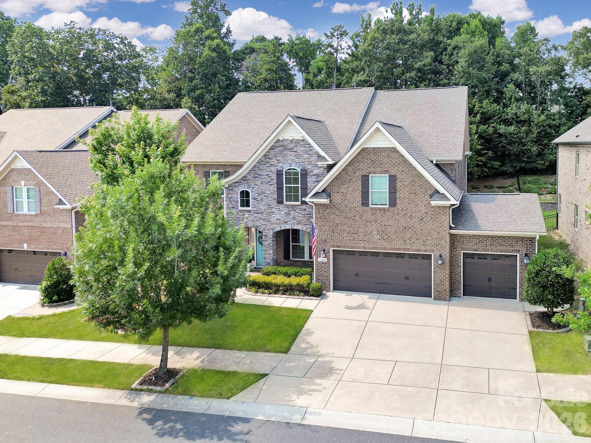 Get ready to be impressed by this stunning all-brick home featuring designer-level finishes in the highly sought-after Brayden community. This 5-bedroom, 4-bath residence offers over 4,400 square feet of beautifully curated living space, showcasing elegant upgrades, modern lighting, and exceptional attention to detail throughout, along with a 3-car garage. From the moment you enter, you’re welcomed by an open-concept layout filled with natural light, highlighted by upgraded 5” hardwood floors that span the main level and extend into the upper hallways. Crown molding throughout the main living areas and a striking coffered ceiling in the dining room—currently styled as a sitting room—add a touch of timeless sophistication. The gourmet kitchen serves as the heart of the home, featuring a spacious quartz island, 5-burner gas cooktop, wall oven, stainless steel appliances, butler’s pantry, and walk-in pantry—perfect for everyday living and effortless entertaining. The kitchen flows seamlessly into the inviting great room with a cozy gas fireplace and a bright breakfast area overlooking the backyard. The main level also includes a private office with French doors, a formal dining space, and a guest suite with a full bath—ideal for visitors. Upstairs, retreat to the luxurious primary suite complete with a sitting area, expansive walk-in closet, and spa-inspired bath featuring a soaking tub, beautifully tiled shower, and dual vanities. Three additional bedrooms are located on the upper level, including one with a private en-suite bath—perfect for guests or teens—while the remaining two share a well-appointed bath with separate vanities for added convenience. An oversized bonus room provides the perfect setting for movie nights, a playroom, or additional living space. The home’s well-planned layout offers both functionality and flow, ideal for everyday living and entertaining alike. Residents of Brayden enjoy exceptional amenities, including a clubhouse, pool, scenic walking trails, playgrounds, and picturesque ponds. Ideally located near top-rated Fort Mill schools and just minutes from shopping, dining, Baxter Village, Kingsley, Earth Fare, and major highways, this home offers the perfect blend of luxury, lifestyle, and location.