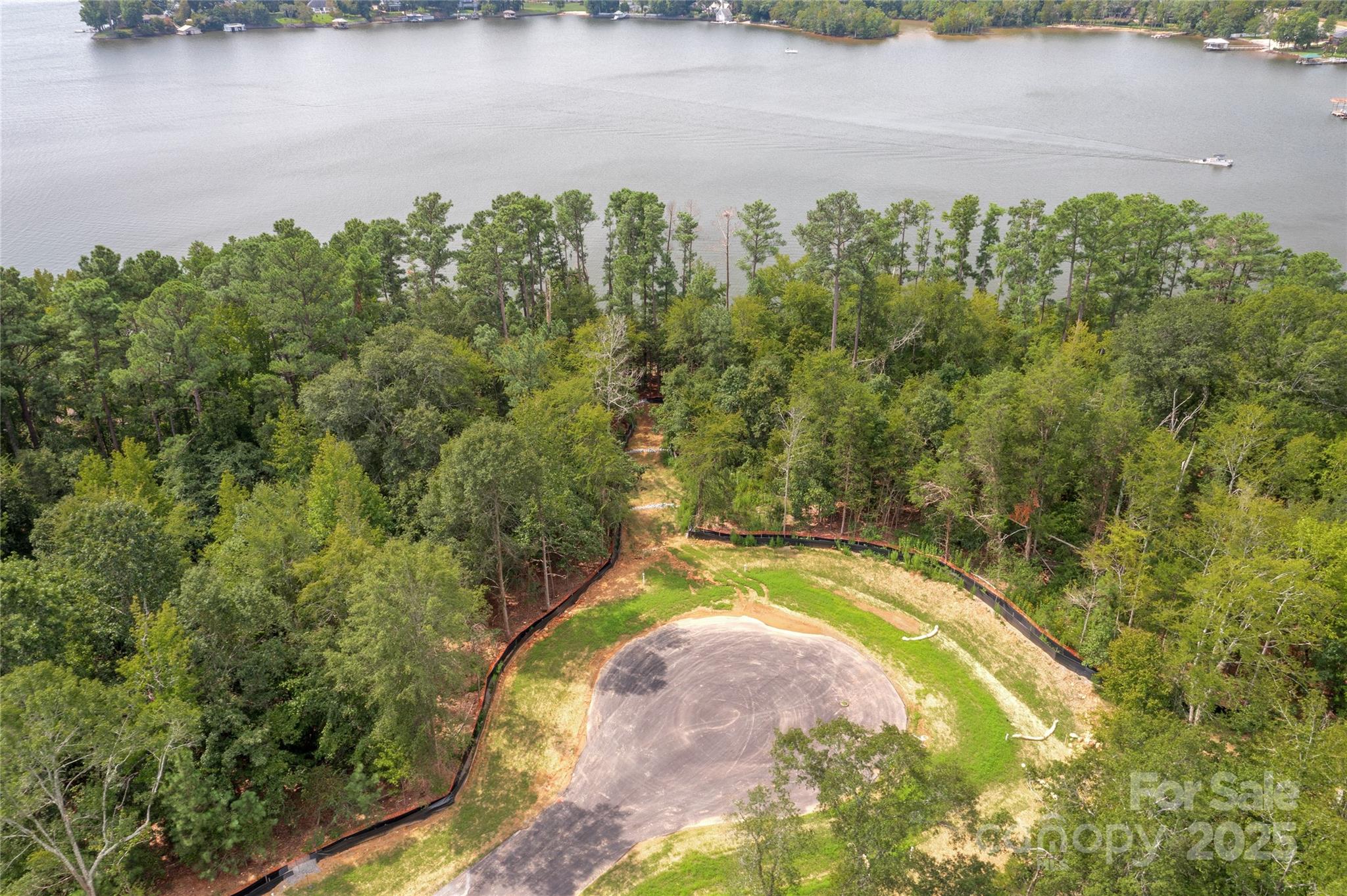Waterfront and dockable homesite in McLean South Shore in Belmont NC on Lake Wylie. Homesite 11 at 1009 Kingbird Lane, Clover South Carolina is located on western edge of the main channel with view south. The homesite catches west and east views as well! An incredible homesite indeed! McLean South Shore offers walking trails, clubhouse, outdoor pool, fitness center, playground. Drift restaurant within walking or golf cart distance. The Carolina Thread trail along Lake Wylie located across New Hope Road. Within minutes of grocery shopping - Publix and Harris Teeter. Plus minutes from the walkable City of Belmont with its quaint vibe, festivals, park, playground, active train line - kids love watching the train, restaurants and shopping. The bustling Charlotte Douglas airport is about 15 minutes away for easy travel access. Uptown Charlotte, South Park and Ballantyne are commutable via nearby highways. Great small town location at doorstep of a bigger city! Premier waterfront community!