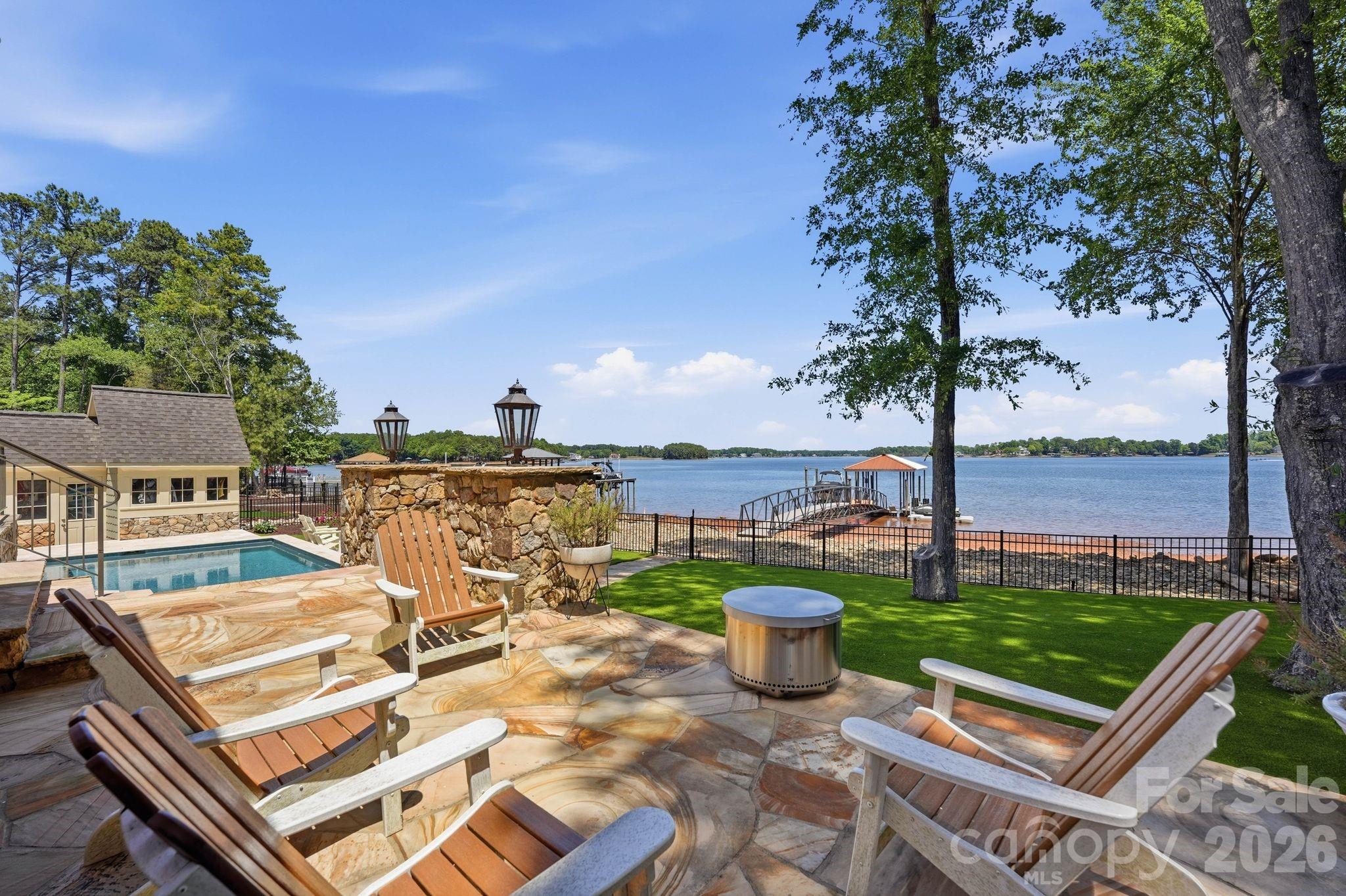 Experience the ultimate waterfront lifestyle at 3900 Channel Point Lane, a stunning property nestled on a private cul-de-sac lot in the highly coveted Sailview community. This home offers a rare and remarkable vantage point with breathtaking, panoramic views of Lake Norman from both the front and the back of the house, ensuring the lake's beauty is your constant backdrop from every angle.
Steps from your back door, you can enjoy a private floating dock and pier, providing effortless access to the main channel for boating or swimming. The waterfront setup is a boater’s dream, featuring a high-capacity boat lift, an additional covered slip for year-round protection, and two dedicated personal watercraft docks for your jet skis. The backyard has been completely transformed into a private oasis featuring a newly installed, high-end saltwater pool and integrated spa. This custom aquatic retreat is finished with a premium pebble tec surface for lasting durability and a natural aesthetic, all easily managed via wireless Jandy controls for seamless operation from your smartphone. Low-maintenance astroturf surrounds the pool area, creating a lush, evergreen space for year-round enjoyment, while the exquisite rear terrace remains perfect for entertaining with its professional-grade built-in grill, granite countertops, and elegant gas lanterns.
Inside, the home has been meticulously updated with modern finishes and refined details throughout. The gourmet kitchen serves as the heart of the home, having undergone a complete transformation to satisfy the most discerning chef. It features an updated layout with a massive center island and stunning new countertops that seamlessly continue up the backsplash for a sleek, contemporary look. The kitchen is fully equipped with high-end, new stainless steel appliances, including a high-performance gas cooktop, all framed by freshly updated cabinetry. Throughout the residence, you will find updated fixtures, graceful archways, and built-in bookshelves that add a touch of timeless sophistication.
The living spaces are designed to maximize the incredible scenery, highlighted by a gorgeous sunroom addition that boasts a stone fireplace, a wet bar, and a wall of windows framing panoramic water views. The spacious main-level primary bedroom serves as a private retreat, featuring a cozy window seat and French doors that open directly to the lakefront terrace. Situated at the end of a quiet cul-de-sac, this home offers rare privacy and unique dual-side lake vistas that are truly hard to find. Residents also enjoy the premier amenities of Sailview, including a clubhouse, community pool, tennis courts, pickle ball and sand volley ball. Don’t miss out on making this lakeside sanctuary your own!
