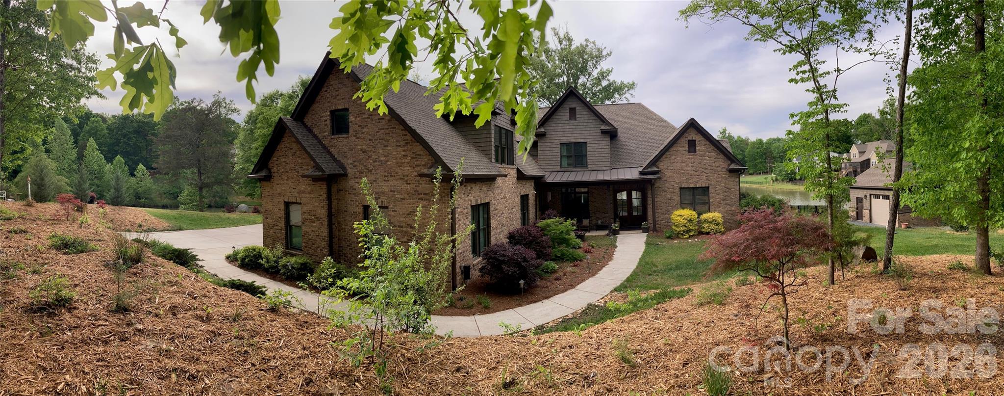 WATERFRONT - This beautiful builder’s custom estate home is situated on a 1.75-acre cul-de-sac lot and features nearly 300 feet of shoreline on the community's private large pond/small lake. Enjoy spectacular 180-degree water views from most rooms and the back of the home, creating a private retreat where you can relax and feel like you are on vacation every day! The property also includes a freestanding shop that could easily serve as a workshop, studio, or private office (with insulation in the walls and ceiling, finished /painted walls, and electricity).  A spacious foyer opens to the formal dining room and an office with a closet and access to the full bath. The large cook's kitchen features granite countertops, an oversized island with seating, abundant custom cabinetry, an induction range (with a gas line run for a gas range option), a microwave, a built-in double oven, and a pantry. The breakfast area easily accommodates a large table and overlooks the scenic lake behind the home. The great room has a fireplace flanked by built-in cabinets, creating a warm and inviting gathering space, also looking out over the lake. The Primary bedroom with Spa-like bath, along with an additional bedroom with a full bath, are on the main floor and have sliding doors to porches, and boast expansive lake views. Ideally located next to a drop zone and garage entrance is the large laundry room with a sink, ample counter space, and cabinets. Upstairs, you will find a huge bonus room with a workout area off the back, two roomy secondary bedrooms, two full baths, a reading/study area, and a media room (or extra flex space). 3-Car side load garage that is extra deep to accommodate larger vehicles. Approximately 700 square feet of walk-in storage area. No steps into the house - the first floor is handicap accessible. Come experience this incredible home and see why its beautiful water views and thoughtful layout make it a truly special place to call your next home!