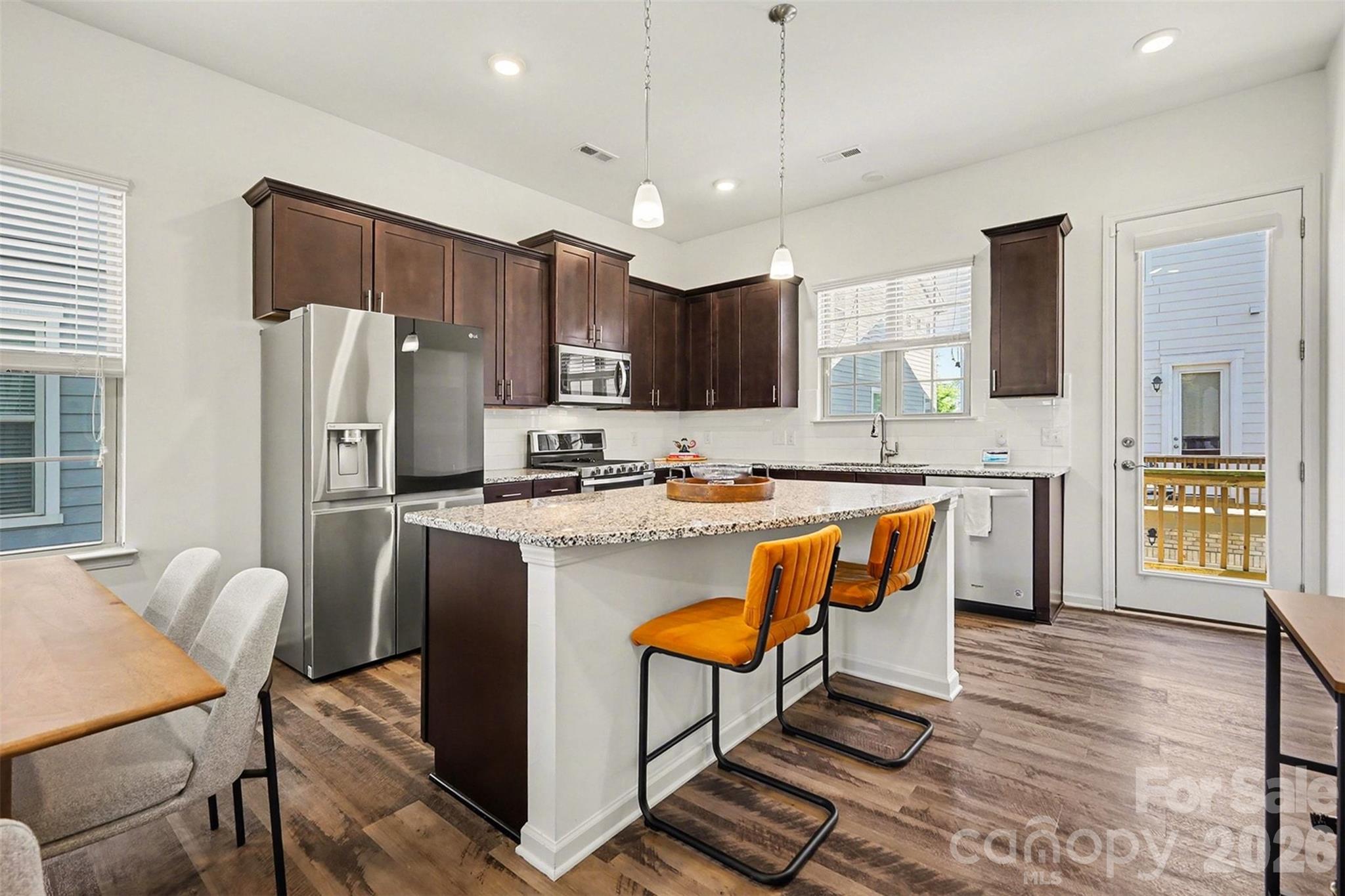 Welcome to this beautifully designed end-unit townhome in the sought-after Hadley at Arrowood Station community, where modern style meets everyday convenience. Positioned to offer added privacy and an abundance of natural light, this home stands out with its charming exterior, welcoming front porch, and thoughtfully designed three-level layout.

Inside, you’re greeted by a bright and inviting entry that leads into a versatile main-level space ideal for a home office, gym, or cozy retreat. The second level opens up into an expansive living area filled with natural light, seamlessly connecting to the dining space and a stunning kitchen designed for both everyday living and entertaining. The oversized island anchors the space, while the open layout creates an effortless flow for gatherings. Just off the main living area, a private balcony offers the perfect place to relax and unwind.

Upstairs, the home continues to impress with a spacious primary suite featuring a light-filled bedroom and a well-appointed en-suite bath, along with an additional bedroom and full bath that provide flexibility for guests or additional living needs. The overall layout is both functional and inviting, offering comfortable spaces across all three levels.

Residents of Hadley at Arrowood Station enjoy access to a beautifully maintained community with a resort-style pool, gathering spaces, and walkable streets that create a welcoming neighborhood atmosphere. The location is truly exceptional, just minutes from the LYNX Blue Line for easy commuting into Uptown Charlotte and South End, along with convenient access to shopping, dining, and everyday essentials. Outdoor enthusiasts will also appreciate the close proximity to Little Sugar Creek Greenway, offering miles of scenic trails for walking, running, and biking.