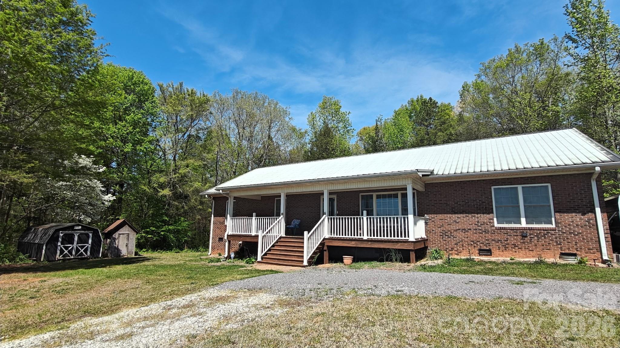 Welcome home to 192 Kluenie Road in Mocksville, NC! This full brick, 3-bedroom, 2-bath home offers approximately 2,080 square feet of well-designed living space. Enjoy 9-foot ceilings throughout, with a cathedral ceiling enhancing the open feel of the great room and dining area. The spacious kitchen provides abundant cabinetry and storage, perfect for everyday living and entertaining. A split-bedroom floor plan offers privacy, with generously sized rooms throughout. Relax on the inviting front covered porch or entertain on the private rear deck overlooking the 2-acre property. Additional features include a 2-car carport, two storage buildings, and a backup wired Generac generator that conveys with the home.