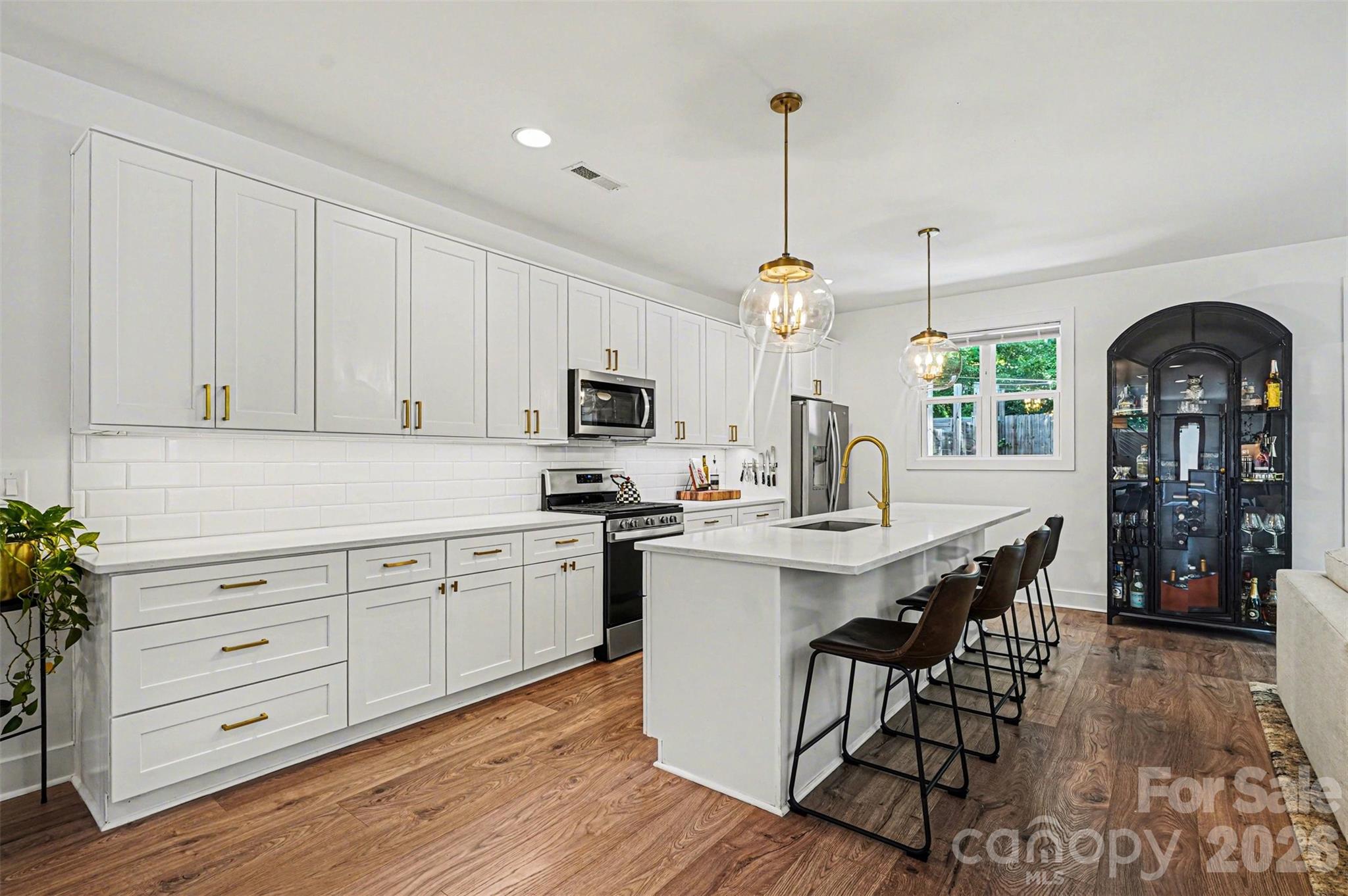This striking contemporary home blends modern design with thoughtful, high-end finishes, creating a space that feels both elevated and inviting from the moment you arrive. The clean architectural lines and curated landscaping set the tone, while a welcoming covered entry with warm wood accents adds an immediate sense of style and intention.

Inside, the home opens into a bright, airy layout filled with natural light and upscale touches throughout. Wide-plank flooring flows seamlessly across the main living areas, complemented by a soft, neutral palette and designer lighting that enhances the home’s modern aesthetic. The kitchen is a true centerpiece, featuring an oversized island with seating, sleek cabinetry, and a polished, open design that connects effortlessly to both the dining and living spaces—ideal for entertaining or everyday living.

The attention to detail continues upstairs, where the primary suite offers a refined retreat with generous proportions, a custom walk-in closet, and a spa-inspired bath complete with dual vanities, elevated finishes, and a beautifully tiled walk-in shower. Secondary bedrooms are equally well-appointed, while additional spaces provide flexibility for a home office, guest rooms, or creative use. The laundry room is thoughtfully designed with built-in storage, adding both convenience and style.

Outdoor living is just as impressive, with a fully fenced backyard designed for both relaxation and entertaining. A spacious patio creates the perfect setting for gatherings, while the private yard offers plenty of room to unwind in a serene, tree-lined setting.

Located in the sought-after Eastwood area of Charlotte, this home places you just minutes from Plaza Midwood, NoDa, and Uptown, offering easy access to some of the city’s best dining, shopping, and entertainment. Enjoy the charm of an established neighborhood paired with the convenience of nearby urban amenities, making this an exceptional opportunity to experience modern living in one of Charlotte’s most vibrant and connected locations.