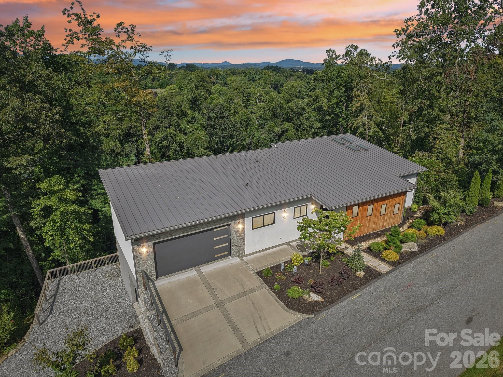 Welcome to a luxurious, modern mountain retreat walking distance to the Ecusta Trail, breweries and cafes, and less than two miles from downtown Hendersonville. This stylish and contemporary 4BR/3.5BA Certified Green-Built home offers nearly 2,700 square feet of light-filled living space, complemented by a 522 sq ft garage—complete with a new 6-seat Bintelli golf cart—and an additional 522 sq ft of unfinished, light-filled flex space ready for your vision.

Thoughtfully designed to inspire creativity and comfort, the home features two open-concept kitchens and living areas, a serene and spacious primary suite, an upper-level Trex deck, screened patio, gym room, and a dedicated office / game room which could easily be converted to a butler’s pantry —perfect for entertaining or accommodating multi-generational living.

High-end upgrades include Hunter Douglas premium blinds, privacy window tint, custom Carolina Closets, premium carpeting, a Ring security system, mature landscaping, and AT&T fiber internet.
Privately tucked away on a quiet cul-de-sac, this property offers a peaceful setting with seasonal mountain views while remaining just minutes from shopping, dining, and outdoor recreation.

Offered mostly furnished, this exceptional home is truly move-in ready and designed for elevated mountain living.

Please contact the listing agent for a full features sheet and to schedule your private showing.