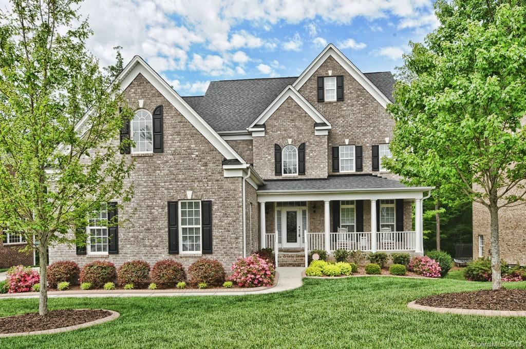 Brick and vinyl home w/ professional landscaping, irrigation, walkout basement.  Heavy custom moulding t/o main floor with hardwood floors t/o! Kitchen w/ granite counters, SS appliances inc 5-burner gas cooktop, wall oven/microwave combo. 42" cabinets. First floor guest suite w access to full bath. 2-sty great room w/ huge palladium style window, gas log fireplace. Upstairs is spacious master ste w/ tray ceiling & ceiling fan, dual closets.Basement w/ stained concrete floor,wet bar, full bath.