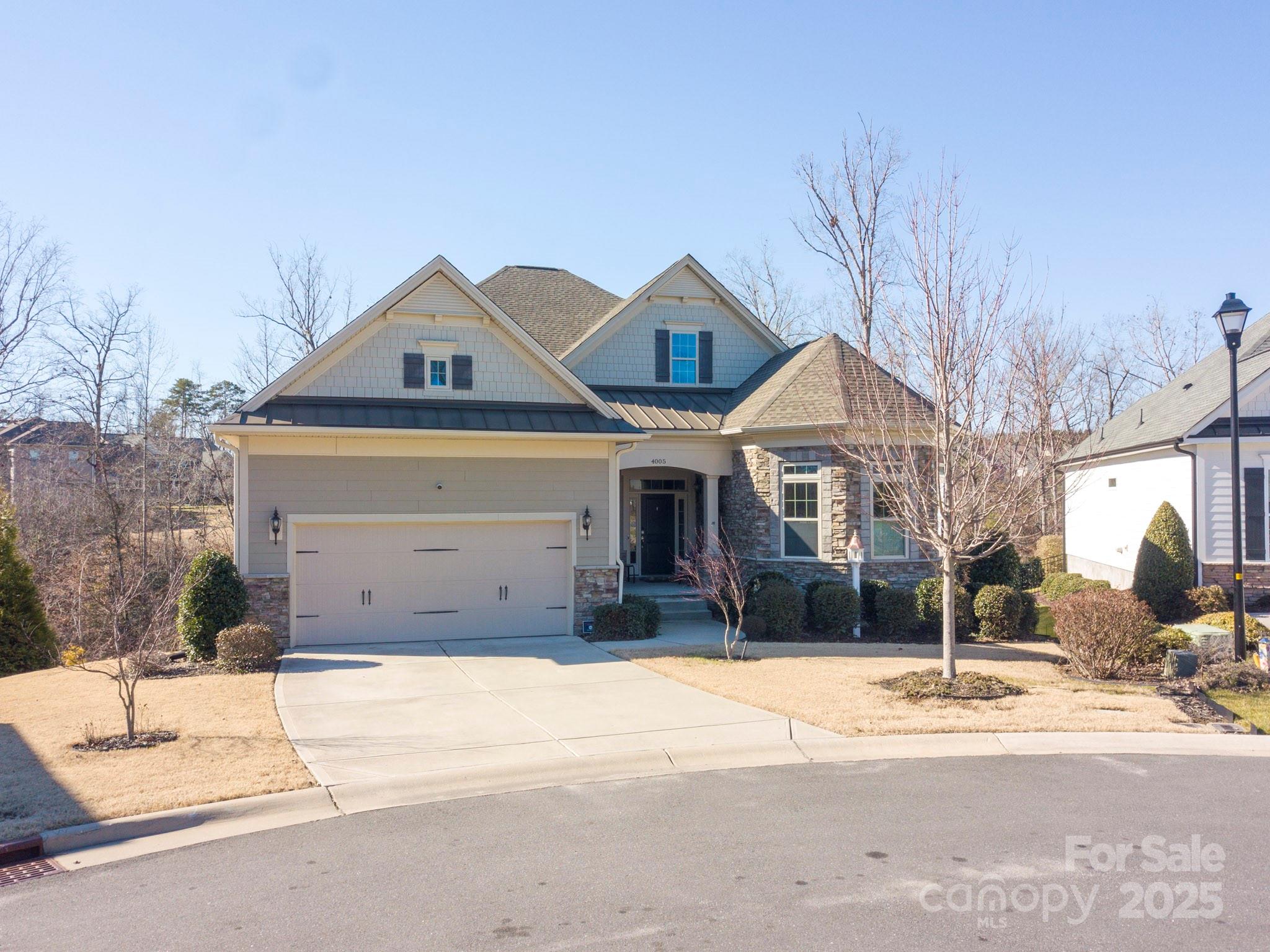 This immaculate one-story home blends privacy, luxury, comfort & functionality. It is located in a small community, nestled on a quiet cul-de-sac that overlooks a private area w/ mature trees & a gently flowing creek. The home features wood floors, high ceilings, 2 spacious bedrooms & generous flex space (currently a DR) & a  fully insulated garage, perfect for working on cars/projects. The kitchen boasts stone counters, 10-foot island w/breakfast bar, built-in oven & microwave, 5-burner gas cooktop, soft-close cabinets & walk-in pantry. GR features a gas FP & 25' wide panoramic sliding-glass doors that lead to a covered deck, perfect for entertaining or unwinding. Deck extends further w/a sitting area, hot tub & retractable awning. Primary suite features a tiled walk-in shower, double sinks & a generous walk-in closet. The fully-insulated, walk-out basement (roughed in for plumbing & HVAC) provides endless possibilities. Lush landscaping & stone accents enhance the homes curb appeal.