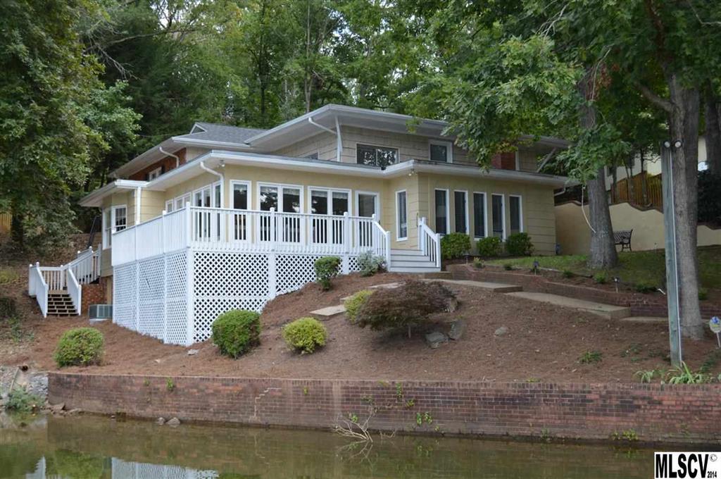 Located in the scenic foothills of the NC mountains, this waterfront retreat offers a private ambiance w/a convenient location near area shopping and dining. This home offers a reversed floor-plan ideal for lake front living positioning the living and dining spaces just steps from the lake front decks and deep cove water frontage. The main lvl of the home offers four bedrooms including the expansive master bedroom w/large en-suite bathroom and walk-in closet. The lake lvl of the home offers a fifth bedroom, den w/fireplace, living room w/built-in cabinetry and wet bar, sun room w/expansive windows framing the water, kitchen w/large bar and ample cabinet space, dining room w/built-in curios, and large laundry room. Decks surround the lake side of the home overlooking the stone walk-ways and boat dock. Deep cove water accommodates all types of watercraft. Highly efficient dual fuel heating and cooling systems are in place in addition to a Rinnai tank-less water heater. Security system.