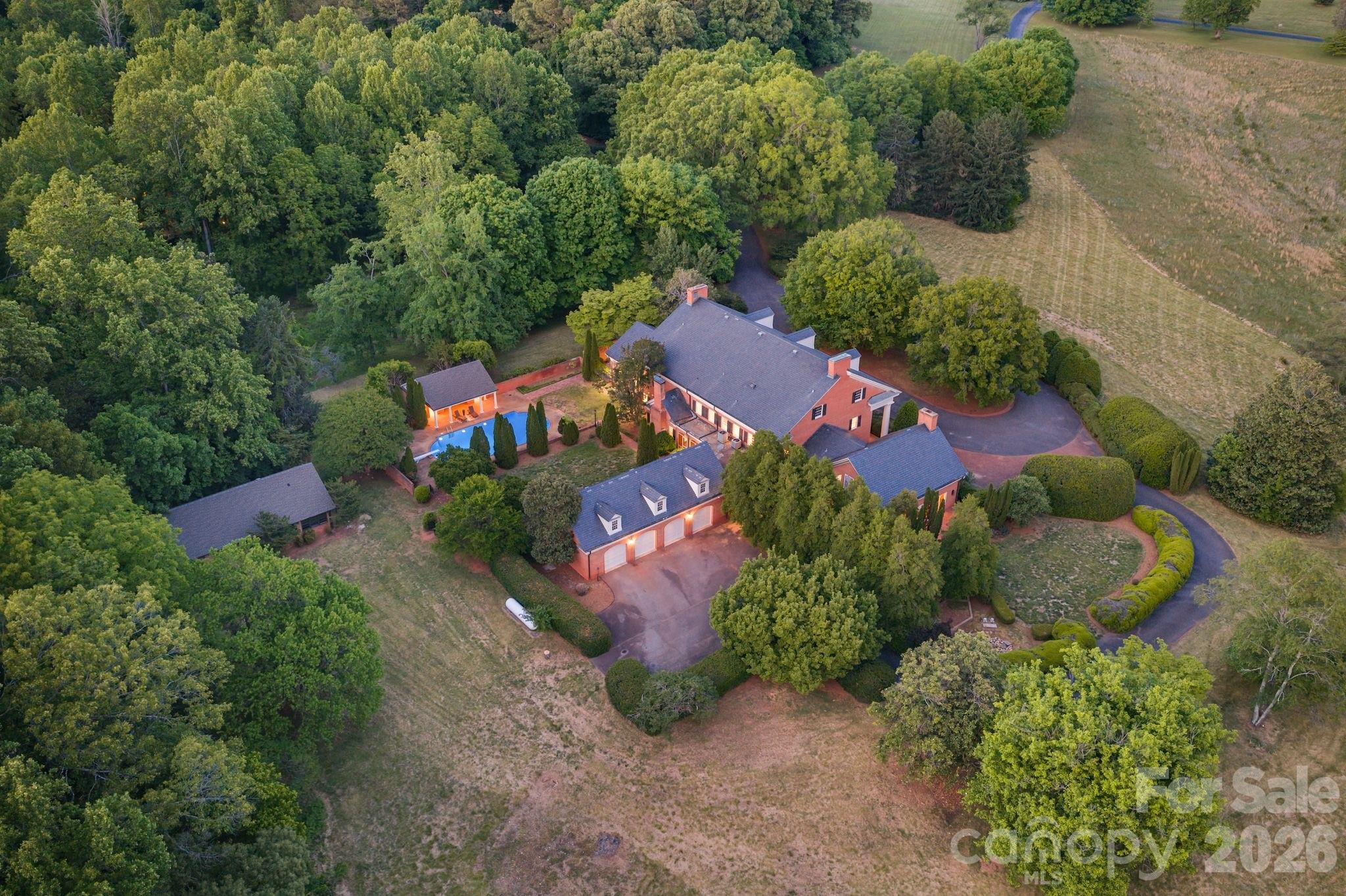 A Once in a Lifetime Estate! Unmatched in Scale, Beauty, and Possibility. Rarely does a property of this magnitude come to market, and this extraordinary estate represents a truly singular opportunity for the discerning buyer. Spanning over 10,000 square feet of refined luxury living and set against more than 32 acres of breathtaking pasture land, this magnificent residence delivers an unparalleled combination of grandeur, privacy, and versatility. To our knowledge, no restrictions have been identified that would limit the property’s use, making it equally suited as a private family compound, an elegant event and wedding venue, a working equestrian or agricultural operation, or simply the ultimate private retreat.
From the moment you arrive, the estate commands attention. Stately white columns frame the front façade in true Southern plantation fashion, setting an immediate tone of timeless elegance. The sweeping circular driveway leads you to a grand entrance where, upon stepping through the front door, you are welcomed by a breathtaking staircase that serves as the architectural centerpiece of the home. Rich hardwood floors extend throughout the residence, lending warmth and continuity to every space.
The chef’s kitchen is nothing short of spectacular, offering an open and inviting floor plan that is perfect for both intimate gatherings and large-scale entertaining. Gorgeous exposed wood beam ceilings add rustic character and charm, while gleaming granite countertops and an abundance of cabinetry deliver the function and finish that discerning buyers expect at this level.
The living room is a showstopper in every sense of the word — a soaring stone wall stretches from floor to ceiling, anchored by a grand fireplace that creates an atmosphere of warmth and drama. Vaulted ceilings of impressive height amplify the sense of space, while an abundance of natural light pours in through generously sized windows, creating an atmosphere that is at once grand and inviting.
The upper level of the home offers extensive additional living space, thoughtfully laid out to accommodate large families or multi-generational living with ease. Walk-in attic storage adds practical convenience rarely found at this scale.
The oversized primary suite is a sanctuary unto itself. Every bedroom in the home is generously proportioned, but the primary bedroom stands in a class of its own. Step directly from the primary suite onto a beautifully appointed private brick patio complete with a soothing waterfall feature an idyllic setting for morning coffee or quiet evening relaxation. The primary bathroom is a true spa experience, finished with exquisite tile work from floor to ceiling, a luxurious walk-in steam shower, and a beautiful soaking garden jetted tub that invites total rejuvenation.
The outdoor living spaces are equally impressive. The backyard features a stunning resort-style pool complemented by a convenient and well appointed pool house, perfect for entertaining guests or enjoying long summer days in complete comfort and style. Bonus room above garage ads unlimited possibilities for an apartment, mother-in-law suite, etc. A detached outbuilding offers tremendous flexibility and could be utilized as a barn, workshop, studio, garage, or converted to suit virtually any need.
The property’s pastoral acreage delivers scenic, picturesque views in every direction, offering a sense of peace and seclusion that is increasingly rare. Whether envisioned as a private family compound, a premier event destination, an equestrian property, or simply a one-of-a-kind luxury residence, this estate stands ready to fulfill the vision of its next fortunate owner. 
Very optimal and usable floored attic space that’s perfect for storage. 

Opportunities of this caliber simply do not come along twice!

Property can be lowered to just below 8 acres for a lower price, see MLS ID 4374269 for more info.