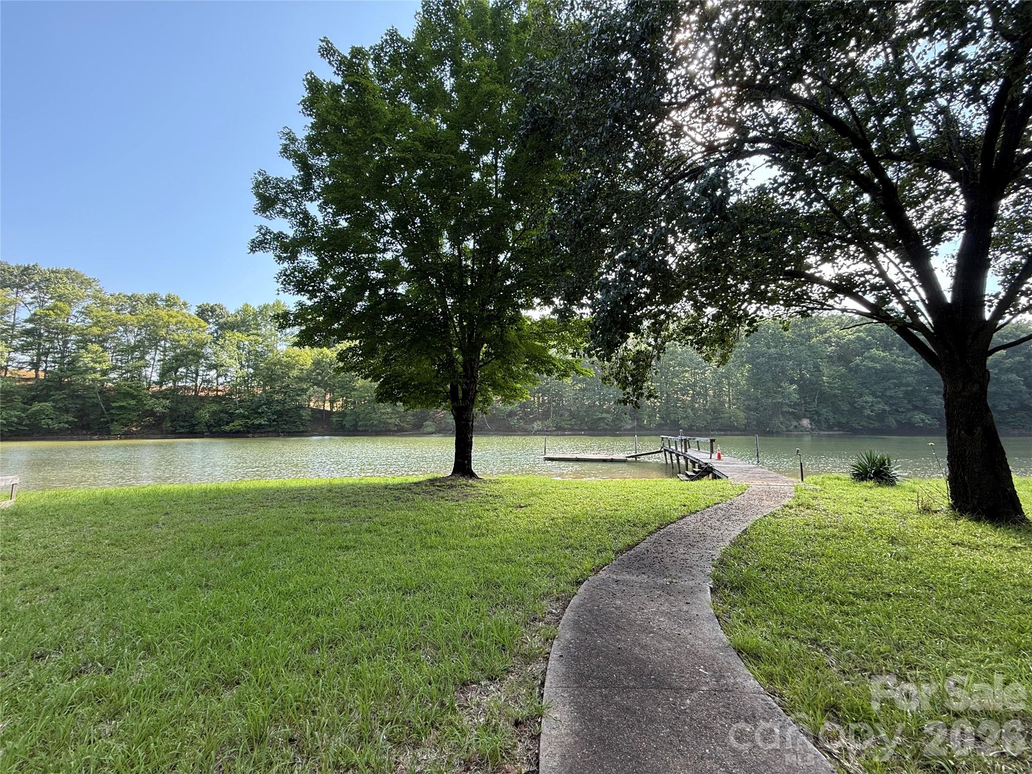 Prepare to be captivated by the breathtaking views of Snug Harbor on Lake Wylie from this exceptional waterfront homesite. Spanning approximately 0.76 acres, this rare property offers the perfect setting to build your dream home and enjoy the best of lakefront living. The gently sloping terrain provides easy access to the water while maintaining privacy among beautiful custom homes, mature hardwood trees, and a natural shoreline. Existing waterfront amenities include a pier and floating dock, making it easy to relax, entertain, or spend the day on the lake. Ideally located within The Palisades area—yet not subject to HOA restrictions—this property offers the flexibility and freedom to create the lifestyle you've always envisioned. A truly remarkable opportunity to own one of Lake Wylie's most desirable waterfront settings.