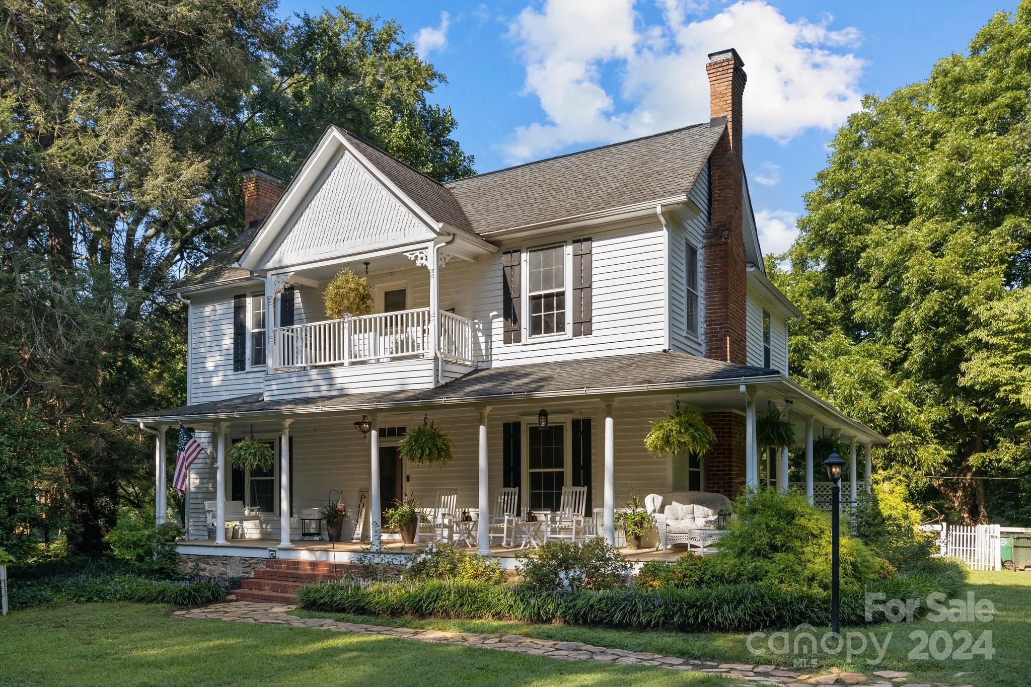RARE opportunity to purchase an absolutely beautiful historic home on 7.6 pristine acres in Clover! With a wrap-around porch and an upstairs balcony overlooking the serene, private yard, you will fall in love with this property. Approx 1.5 acres is fenced and there is a barn that's perfect for small farm animals. New upstairs HVAC has a CIMR air purification system that services the entire home, and the sellers have installed a dehumidifier in the cellar and new vapor barrier in the crawlspace with a transferable warranty. Original hardwoods, doorknobs, fireplaces, moldings and built in cabinets add historic charm, while modern upgrades such as lighting, a new vanity and a claw tub in the primary bath, shiplap and granite counters provide comfort and peace of mind. The primary bedroom is on the main level with 4 more spacious bedrooms and 2 full baths upstairs. Circular driveway and a carport with an electric car charger. Clover Schools and Low Taxes! Don't let this one get away!!