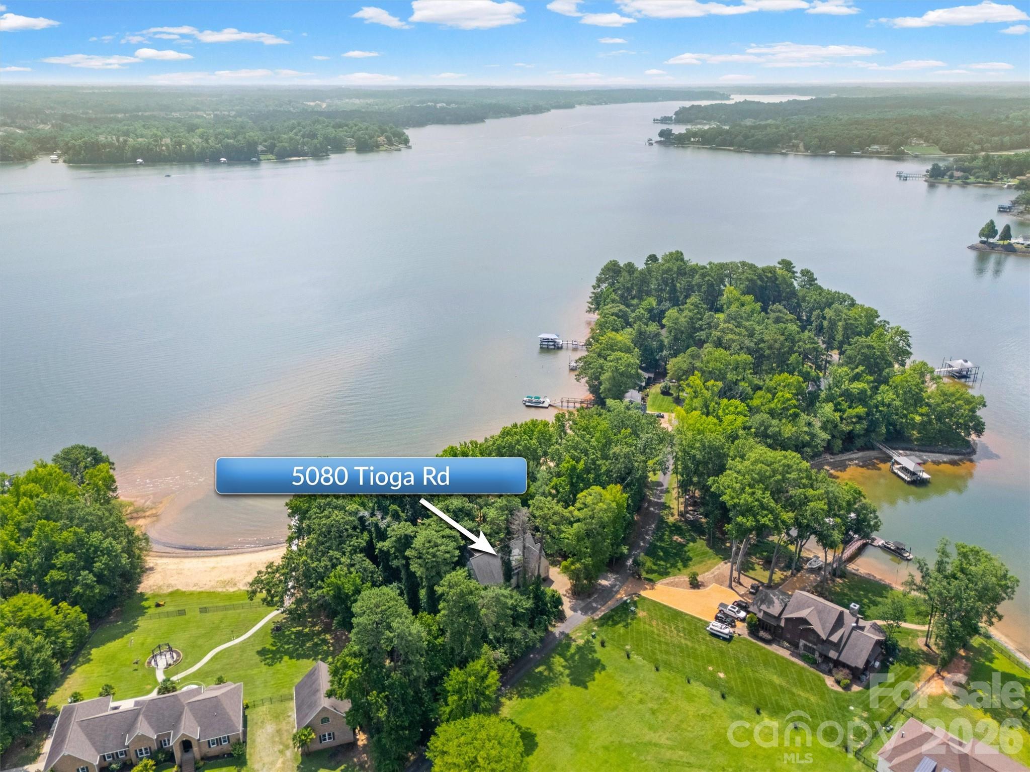 Custom-built waterfront home by Arcadia Homes on ~1 acre, offering approximately 400 feet of shoreline and one of the largest natural sandy beaches on Lake Wylie. Enjoy breathtaking main channel views from a private peninsula within a gated community. Property is adjacent to desirable Beaver Dam Cove -- one of the lake's premier boating destinations.

The outdoor living experience is exceptional, featuring a spacious, level backyard, a private sandy beach, mature trees for privacy, and unobstructed lake views with no neighboring homes visible from the patio. A private dock with boat lift and extra large swim platform makes enjoying the lake effortless, while the outdoor shower provides a convenient place to rinse off after a day on the water.

Inside, the thoughtfully designed floor plan combines luxury with functionality. The chef's kitchen features custom finish maple cabinetry, a gas range, built-in wine refrigerator, beverage drawers, and generous workspace, all flowing seamlessly into the dramatic two-story great room. A soaring 24-foot vaulted ceiling and a spectacular 13-foot high wall of windows fill the home with natural light and showcase panoramic lake views.

The flexible main-level bonus room is ideal as a game room, home office, or guest space. This custom home also features 8” wide Hickory hardwood flooring, 5 piece crown molding, 9” high baseboards,
custom closet systems with drawers in each bedroom, and Pella Windows.

Additional highlights include:
* Freshly painted interior
* 10-foot ceilings on the main level and 9-foot ceilings upstairs
* Two walk-in attic storage areas
* Whole-house water softener
* New tankless water heater (2025)

Don't miss this rare opportunity to own a custom waterfront retreat that combines exceptional craftsmanship, privacy, expansive outdoor living, and one of Lake Wylie's most unique private beach settings.