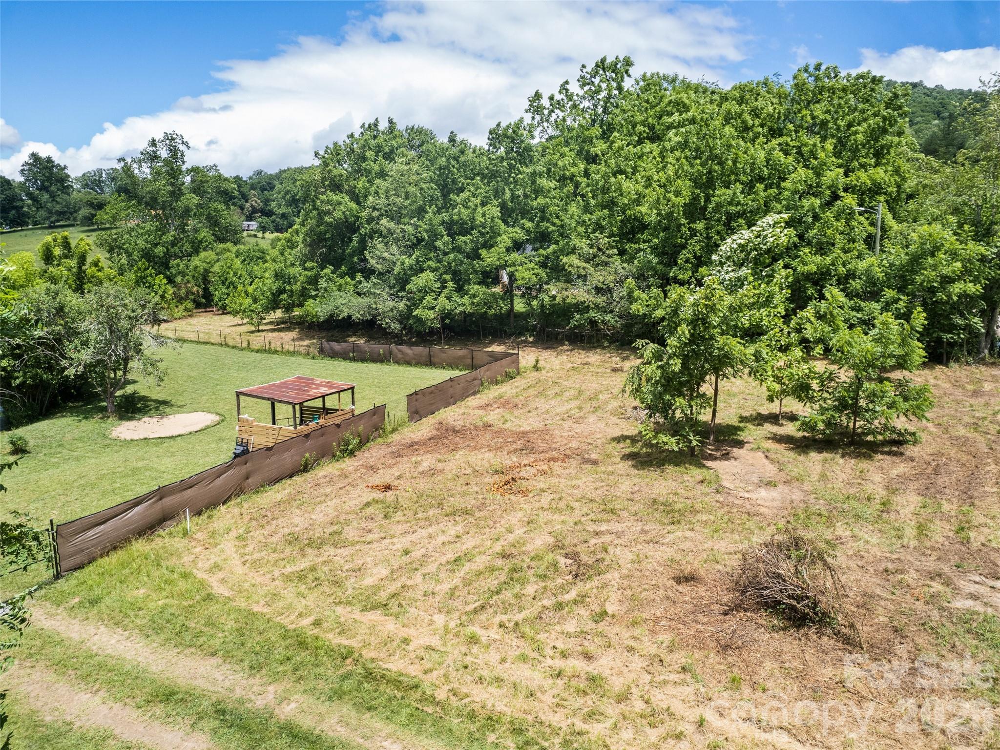 Rare opportunity to own 1.65 level acres just beyond the Biltmore Lake community in Candler. This lightly wooded parcel offers a peaceful setting with a small creek running along one side, creating a natural backdrop for your future home. Located on state maintained Lollis Road, this property combines accessibility with a sense of privacy. With OU zoning and NO restrictions, the possibilities are wide open. Bring your builder and create the space that fits your vision. The level topography supports an easier build, while the need for well and septic allows for a fully customized setup. A unique chance for a convenient location near W AVL and surrounding amenities.