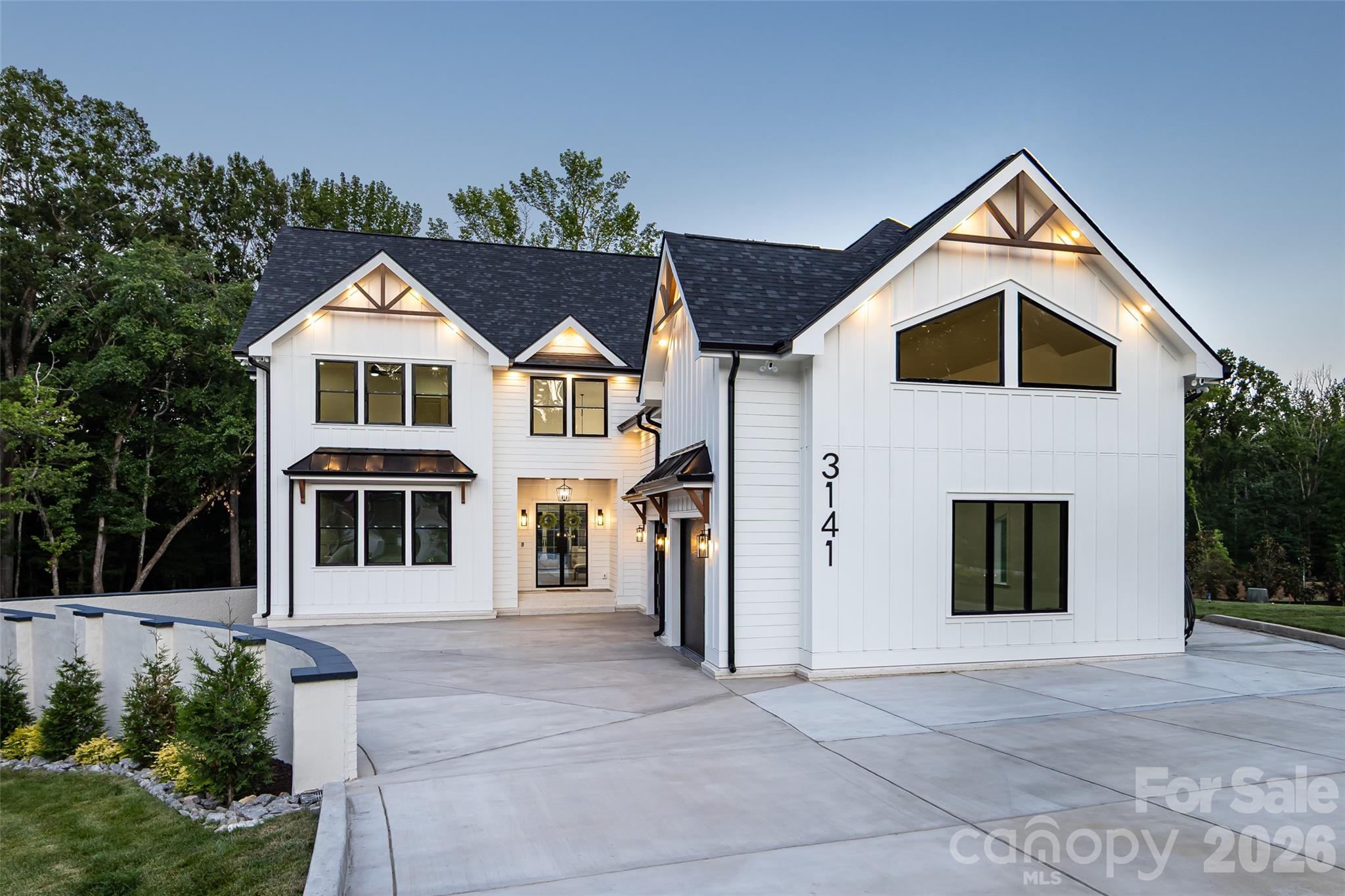 Experience exceptional craftsmanship and sophisticated design in this stunning new construction luxury residence, where timeless modern farmhouse architecture meets today's most sought after finishes. From the striking white exterior accented with black windows, metal roof details, and decorative timber trusses to the inviting covered front entry, every detail has been thoughtfully curated to make a lasting impression.

Step inside to an expansive, light filled floor plan designed for effortless everyday living and unforgettable entertaining. The spacious great room showcases soaring ceilings with exposed wood beams, designer lighting, and an impressive wall of sliding glass doors that seamlessly connects the indoor living space to the covered outdoor porch, creating the perfect indoor outdoor lifestyle.

At the heart of the home, the chef inspired kitchen is both elegant and functional. Featuring an oversized quartz island with seating, custom cabinetry, abundant storage, premium built-in appliances, designer pendant lighting, and a spacious walk-in pantry, this kitchen is ready to host everything from casual family meals to large gatherings. Adjacent dining and living spaces flow beautifully together, offering an open yet inviting atmosphere.

The covered rear porch serves as a true extension of the home, highlighted by a warm wood-paneled ceiling, modern lighting, and generous space for dining, relaxing, and enjoying peaceful views year-round.

Throughout the home, you'll find elevated finishes including wide plank flooring, custom millwork, contemporary fixtures, oversized windows that flood the interior with natural light, and carefully selected designer details that create a refined yet comfortable living experience.

With its impeccable craftsmanship, thoughtful layout, and luxurious finishes, this home offers the perfect blend of elegance, comfort, and modern functionality. A rare opportunity to own a beautifully designed new construction home built for the way you live today.
