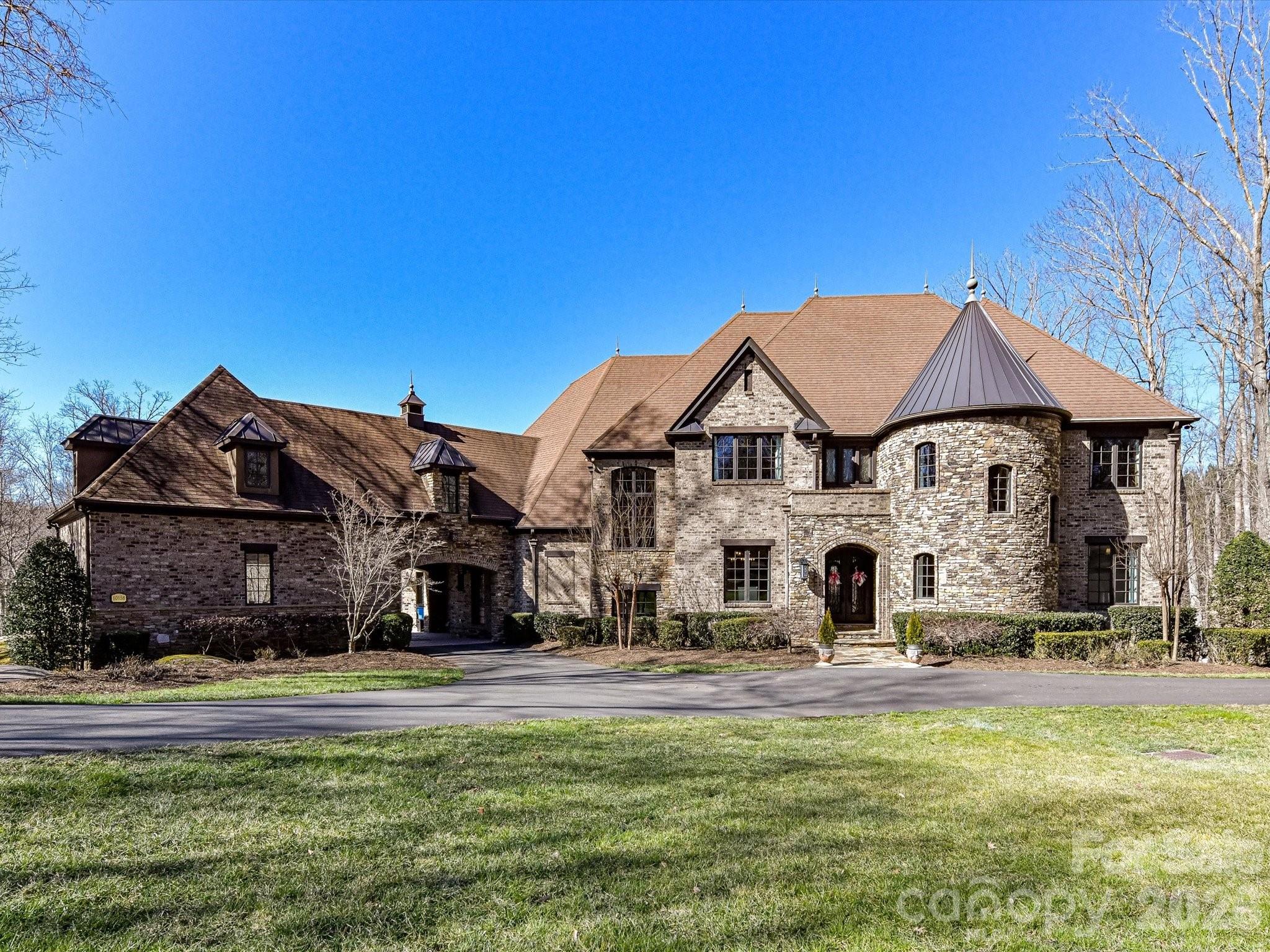 Welcome home to an extraordinary resort-style retreat where luxury, privacy, and thoughtful design come together in perfect harmony. Nestled on 7.25 beautifully wooded acres within the highly sought-after gated community of "The Enclave", this remarkable estate offers an unparalleled lifestyle in a serene and secure setting. From the moment you arrive, you’ll appreciate the sense of exclusivity and tranquility that surrounds the property. Step inside to discover a stunning open-concept floor plan designed for both everyday living and grand-scale entertaining. The heart of the home is the impressive custom-built gourmet kitchen, a true showpiece that will delight any culinary enthusiast. Featuring two oversized islands—one complete with a chef’s butcher block—this space provides abundant prep room, seating, and gathering areas. High-end finishes, custom cabinetry, and premium appliances create a kitchen that is as functional as it is beautiful. The main-level primary suite serves as a private sanctuary, thoughtfully positioned for comfort and convenience. This luxurious retreat features a spa-inspired bath with a dramatic walk-through rain shower, elegant finishes, and a serene ambiance designed to help you unwind at the end of the day. Step outside and prepare to be captivated by breathtaking views of your private wooded estate. The backyard has been transformed into a true oasis, offering resort-style amenities that rival the finest vacation destinations. Relax in the heated saltwater infinity pool, soak in the hot tub, or gather with friends around the wood-burning fireplace. The soothing sound of cascading waterfalls enhances the peaceful atmosphere, making this outdoor living space ideal for both entertaining and quiet evenings under the stars. Upstairs, you’ll find five generously sized guest bedrooms, providing ample space for family and visitors. A dedicated office offers a quiet workspace, while the home gym allows you to maintain an active lifestyle without ever leaving the comfort of your home. The walk-out basement is an entertainer’s dream. Designed with versatility in mind, this level features a cozy great room, a spacious entertainment and game area, a private home theatre, an additional guest bedroom, a full bath, and a playroom—creating the perfect environment for hosting gatherings, movie nights, and celebrations of all sizes. Ideally located in a top-rated school district, this exceptional property is just minutes from Concord Regional Airport and offers convenient access to major highways, shopping, dining, and entertainment. Despite its proximity to everything you need, the estate maintains a peaceful, tucked-away feel that is truly rare. This is more than a home—it is a lifestyle. A rare opportunity to own a private estate in "The Enclave" where luxury living meets everyday comfort. This is truly a must-see property.  Just 16 minutes to downtown Davidson, NC. The home has 6 rooms being used as bedrooms, but the septic permit is for 5 bedrooms.