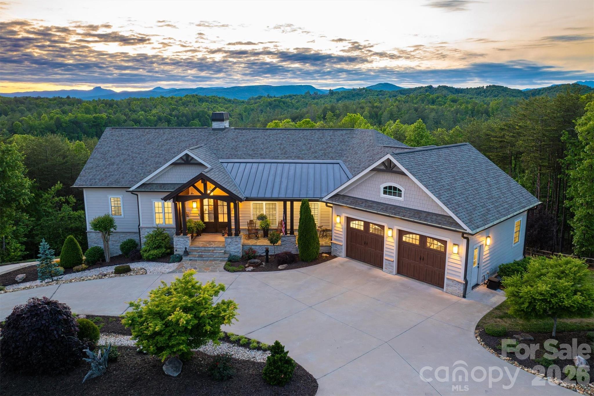 Achieving this level of style, grace, and beauty typically takes decades to plan and curate in a home; this beautifully adorned Southern home is truly timeless. On 2 acres, there are over 7,500 sq ft under roof on 2 levels, including decks and porches. The deep flagstone front porch is a welcoming spot. The grand front entry has arched double French doors with restoration glass panes, illuminated by a Swarovski crystal chandelier. The living room's vaulted ceilings lead your eyes to unbelievable views of Table Rock, Brown Mountain, and Adams Knob, framed by floor to ceiling windows and sliding glass doors that open to the back porch and deck. A transom of arched windows bathes the living room w/natural light • The upper deck and porches are 14 ft deep with vaulted tongue and groove wood ceilings, composite flooring and massive support beams. The kitchen: Luxurious Cambria quartz countertops •.Under cabinet task lighting • Eye-catching trompe-l'œil tile backsplash • An elegant BLANCO farm sink in an expansive island with bar seating• Premium Bosch appliances, including wall oven and microwave • Lighted upper transom cabinets w/glass doors. Wall of floor to ceiling cabinets w/matching enclosed refrigerator surround • Walk-in pantry w/etched glass door, upper shelves, lower pull-out shelves, quartz counter tops. A bright cozy separate eat-in dining area faces spectacular mountain views. • The Primary BR Suite is a masterclass in luxury, blending comfort with world-class amenities. A bay window takes in endless mountain views. The spa-inspired bath. Boasts heated floors, a Mr. Steam aromatherapy steam room, and a stunning Victoria & Albert soaking tub. With custom-organized His&Hers walk-in closets and high-end finishes like Hansgrohe fixtures and Laufen ceramic sinks, every inch exudes quality and luxury living. Downstairs, the den has Scandi-style elevated architectural elements and an ambience of refined luxury.  11-foot white walls include a 3-dimensional white stone feature wall with built-in, sleek, linear fireplace.  Dark wood alcove cabinets and floating shelves flank the fireplace wall.   A bank of four glass doors opens to the porch and mountain view, while sustaining an abundance of natural light. The bar, with the timeless grandeur of a classic gentleman’s club, is a sanctuary of deep-rooted tradition. The custom dark-wood cabinetry is detailed with dramatic molding and trim. Granite countertops gleam from under-cabinet lighting. Shimmering glass-front doors reveal a glimpse of glassware, while romantic industrial pendant lighting by Nick Alain casts a warm, designer glow.  Equipped with a whisper-quiet Bosch dishwasher, a BLANCO sink paired with a sleek Hansgrohe pull-out faucet, and a spacious double-bar refrigerator, the bar is tailored for the refined entertainer. • Music Room w/built-in cabinets • Craft Room w/built-in cabinets • Exercise Room w/wall of mirrors • Wine Cellar with artisan, hand-crafted, Charlotte Grapevine arched metal door • Carpeted XL panic/safe room w/built in shelves • 22Kw automatic whole house generator• Oversized Pressure tank =less interruptions of water delivery, extended life of well pump •  Rinnai tankless water heater • Recirculating hot-water loop • Whole house Humidifier upper level • Whole house De-humidifier lower level • Full security camera system and monitored alarm system • Whole house generator • 500 gallon buried propane tank. The Coves Mountain River Club is a 3,200 acre gated community on Johns River. Amenities: trail system, river access areas, picnic pavilions. 2 Equestrian Centers. Community Garden. Vineyard. Dog Park. Mountain-top clubhouse, pool, fitness center, locker rooms, kitchen, viewing decks, fire pits and more! Over 30 clubs to join! 500K acre Pisgah National Forest and Wilson Creek River Area are across the road! 1.25 hour drive to Charlotte/Asheville, mins to Lenoir, Blowing Rock, Morganton, and Blue Ridge Parkway.
