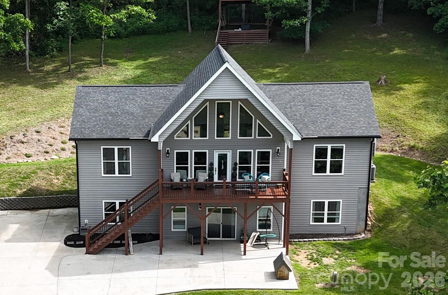 If you've been dreaming of the perfect Western North Carolina mountain home, this is the one you've been waiting for!

Nestled among the trees on 2.43 acres with breathtaking long-range mountain views, this exceptional 3-bedroom, 3-bath home offers the peaceful mountain lifestyle buyers are searching for when relocating to Asheville and the surrounding communities. From the moment you arrive, you'll feel transported to your own private retreat, where every detail is designed to embrace the beauty of the Blue Ridge Mountains.

The expansive covered front porch is the showpiece of the home, offering panoramic mountain vistas and floor-to-ceiling windows that bring the outdoors in. Enjoy morning coffee surrounded by nature, spend afternoons watching the seasons change across the ridgelines, and end your day in the gazebo perched above the home, perfectly positioned to capture unforgettable sunset views.

Inside, the spacious open-concept floor plan is ideal for gathering with family and friends. The living room, dining area, and kitchen flow seamlessly together around a modern fireplace, creating the warm mountain ambiance everyone envisions for their dream home in the mountains. The split-bedroom floor plan provides privacy, while the oversized primary suite offers a luxurious escape with a spa-like bath featuring a soaking tub and separate shower.

The lower level adds incredible flexibility with a fully equipped second living space featuring high ceilings, large windows, interior and exterior access, separate parking, a covered patio, kitchen, and bath. Whether you're looking for a private guest suite, multigenerational living arrangement, mother-in-law quarters, short-term rental potential, home office, recreation room, or media space, this area offers endless possibilities.

Additional features include a 2-10 structural defect warranty that transfers to buyer at closing good till 2030. The home has durable hardboard siding, a composition shingle roof, an oversized two-car garage with workshop and storage space, a electric vehicle charger station and a greenhouse with power for year-round gardening enthusiasts.

Located just minutes from downtown Mars Hill, you'll enjoy easy access to local restaurants, shops, and community events, while also being near Mars Hill Elementary School, Bailey Mountain Preserve, the Greenway, and Mars Hill University. For added convenience, the new AdventHealth hospital currently under construction in Weaverville is approximately 12 minutes away, while Asheville's vibrant dining, arts, and outdoor recreation scene remains within easy reach.

Rarely does a property combine privacy, views, versatility, and convenience so effortlessly. Whether you're searching for a primary residence, mountain getaway, multigenerational home, or relocation destination near Asheville, this remarkable property delivers the mountain lifestyle you've always imagined.