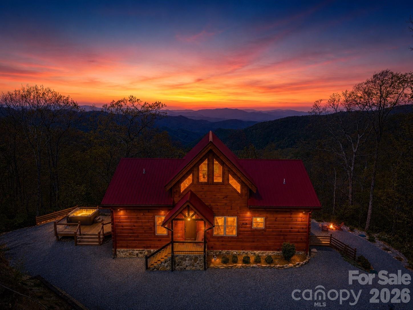 Custom-built real log cabin at 4,100 feet elevation in the prestigious Alarka Highlands community offering breathtaking long-range views w/ 7 mountain layers looking into the heart of Great Smoky Mountains National Park! This luxury 3BR/3.5BA retreat features soaring ceilings, walls of windows, distressed hickory floors & a stunning floor-to-ceiling stone gas fireplace in the great room. The chef’s kitchen includes high-end stainless appliances, gas range w/ double ovens, quartz countertops & abundant cabinetry flowing into the dining area. Split floor plan w/ 2 primary suites on the main level, each offering walk-in closets, tile showers & private deck access to enjoy the incredible views. Spacious loft provides flexible space for an office, bunk room, or sitting area. Finished basement is designed for entertaining w/ a 2nd fireplace in the family/game room, 3rd bedroom, full bath & walkout access to the covered patio & firepit. Expansive decking plus an oversized side deck w/ hot tub & grilling area create exceptional outdoor living spaces. Situated on 4.77 private acres w/ high-speed Balsam West internet & a 24KW Generac generator. Offered turnkey with high end furnishings!