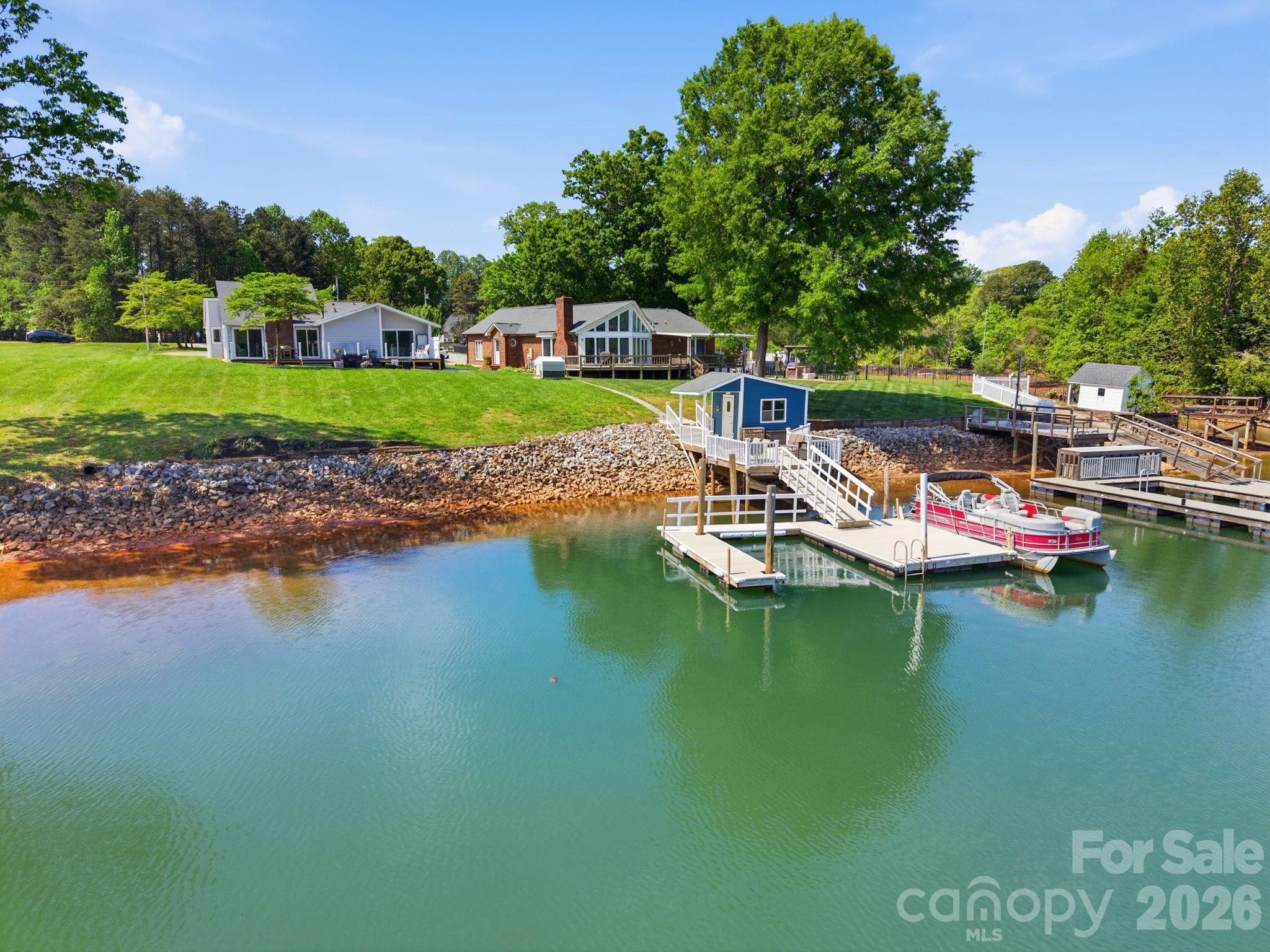 Welcome to lakefront living at its finest on Lake Norman. This completely remodeled ranch-style home offers three bedrooms, two baths, and showcases breathtaking long-range water views, deep water, and a rare flat lot, an ideal combination for both everyday living and entertaining.  From the moment you step inside, you’re greeted by an abundance of natural light and expansive windows that perfectly frame the stunning lake views throughout the home.  Recent updates include all new luxury vinyl plank flooring, fresh interior paint, crown molding, modern light fixtures and more, creating a clean, cohesive, and move-in-ready feel.  The beautifully updated kitchen features LG stainless steel appliances, granite countertops, recessed lighting, and thoughtfully repurposed cabinetry. A built-in wine fridge and dedicated coffee station add both charm and functionality, making this space perfect for hosting or enjoying quiet mornings at home.  The living room impresses with soaring ceilings and panoramic water views, offering a bright and airy atmosphere with a touch of luxury.  The single-level layout includes two spacious secondary bedrooms and a serene primary suite with a walk-in closet, water views, and direct access to the deck, your own private retreat.  Both bathrooms have been tastefully renovated with updated tub/showers, granite countertops, refreshed cabinetry, and new fixtures.  Step outside to enjoy the newly added patio, grilling area, and low-maintenance composite deck, perfect for taking in the peaceful surroundings.  A stone walkway leads to the dock, featuring a new vinyl walkway and railing, along with a grandfathered boathouse, a rare and valuable feature on Lake Norman.  Ideally situated in a deep-water cove just minutes from the Hwy 16 & 73 intersection, this home offers a quick commute to Charlotte and the airport while still providing the tranquility of lakeside living.