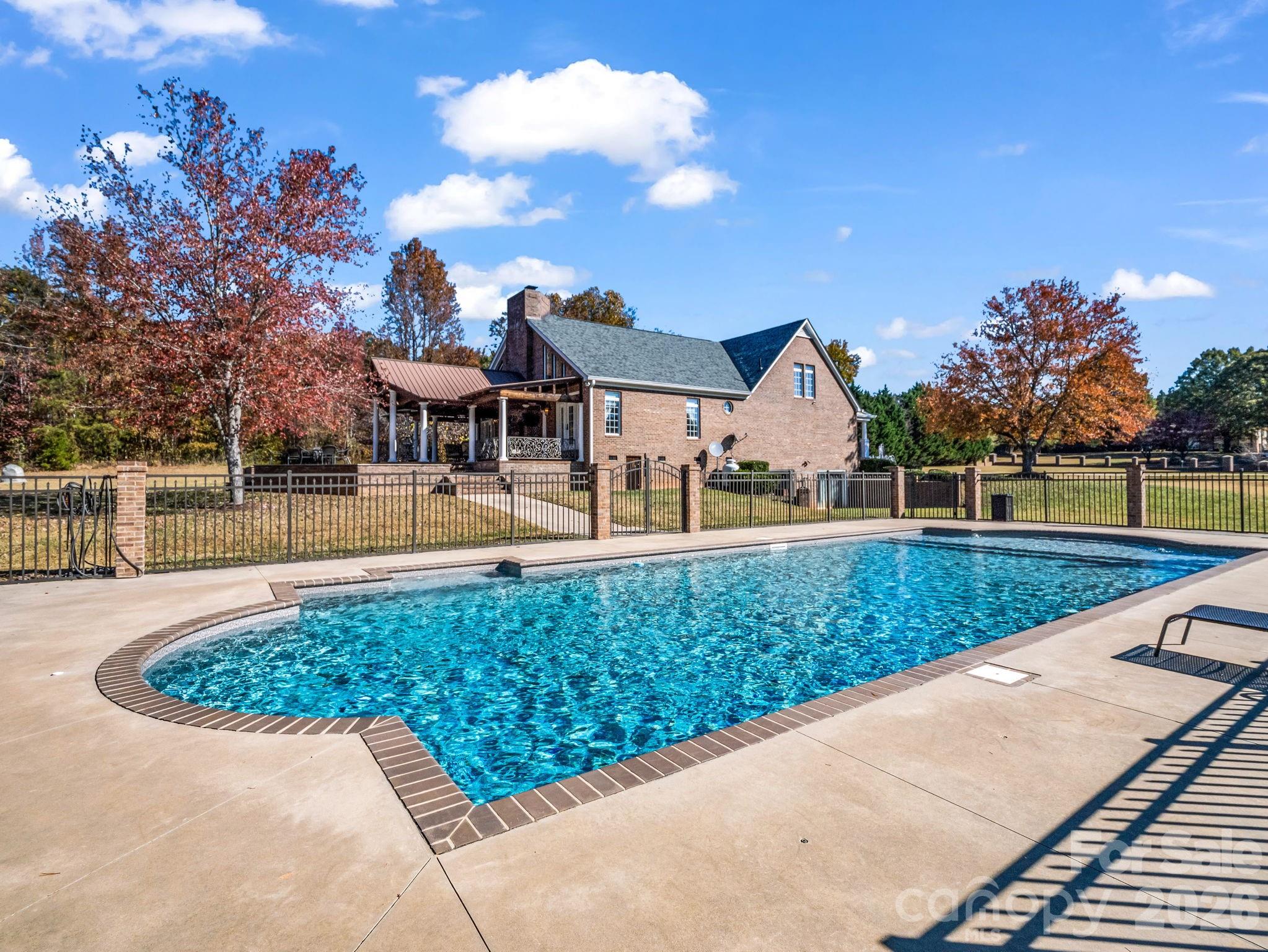 Stunning home on 5.97 acres with so many desirable amenities! Lots of space for large families or entertaining! Inside you'll find over 4500 SF with 3 BRs, 3.5 baths, 2 flex rooms, foyer, kitchen,dining rm,& a huge great room with fireplace & overlook from upstairs. But that's just the beginning!  The basement has a 5.1 surround sound movie theatre with digital laser projection plus a spacious game room. Outside you'll find a very large & inviting covered patio with a beautiful wood-burning fireplace!  There's plenty of extra space for entertaining especially after everyone enjoys the beautiful endless pool! It's very rare to find this type pool which has jets for endless swimming! The primary bedroom is on the main level. It has a tray ceiling with indirect lighting.  The primary bath has his & her walk-in closets, a double vanity,  jetted tub, and a huge shower with multiple shower heads & jets. Kitchen has beautiful cabinetry, granite countertops, double oven, two pantries, & a breakfast area. There is also a dining room with built-in lighted cabinets.  There is custom ironwork railings on both front & back porches that add beauty & preeminence to this home! You'll love the circular driveway & a beautiful fountain out front.  Double garage has lots of storage overhead with permanent stairs. Roof was installed in 2025, New pool liner in 2024, and 2 new heat pumps in Nov. 2022. Security system. You don't want to miss this one!  Call for more details!