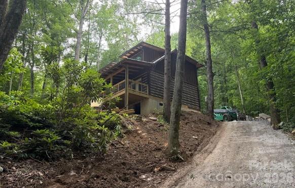 Experience the timeless charm of mountain living in this BRAND-NEW handcrafted log cabin, built with impressive 6-inch hewn logs and thoughtfully designed for comfort, beauty, and connection to nature. The heart of the home is an inviting open-concept living area where the kitchen, dining, and living spaces flow seamlessly together beneath soaring tongue-and-groove ceilings. A stunning stone fireplace creates a warm focal point, while French doors open to a spacious covered porch, perfect for enjoying peaceful mountain mornings and evening sunsets.

The main-level primary suite offers a private retreat with French doors leading directly to the porch and overlooking the large, level yard. The suite features a walk-in closet and a beautifully appointed ensuite bath with tasteful tile finishes. Outside, the expansive yard provides plenty of room to relax and entertain, complete with a firepit and a picnic pavilion planned for construction.

Upstairs, a generous loft captures scenic views and offers flexible space for a home office, recreation area, or additional sleeping accommodations. A second bedroom, full bathroom, closet space, and convenient laundry area complete the upper level.

Built by a local log home builder with quality and longevity in mind, this home features a durable metal roof that is perfect for peace of mind and listening to those raindrops in the quiet comfort of your home, high-end finishes throughout, and exceptional privacy. Currently in the final stages of construction, this cabin offers the rare opportunity to own a brand-new mountain retreat that perfectly blends rustic character with modern comfort.

Still to be completed:
-Concrete Driveway
-Firepit
-Outdoor separate covered seating area
-Interior finishes
-Hardwood floors through most of the home

This is your chance for a solidly built, NEW home for primary living or a second home!