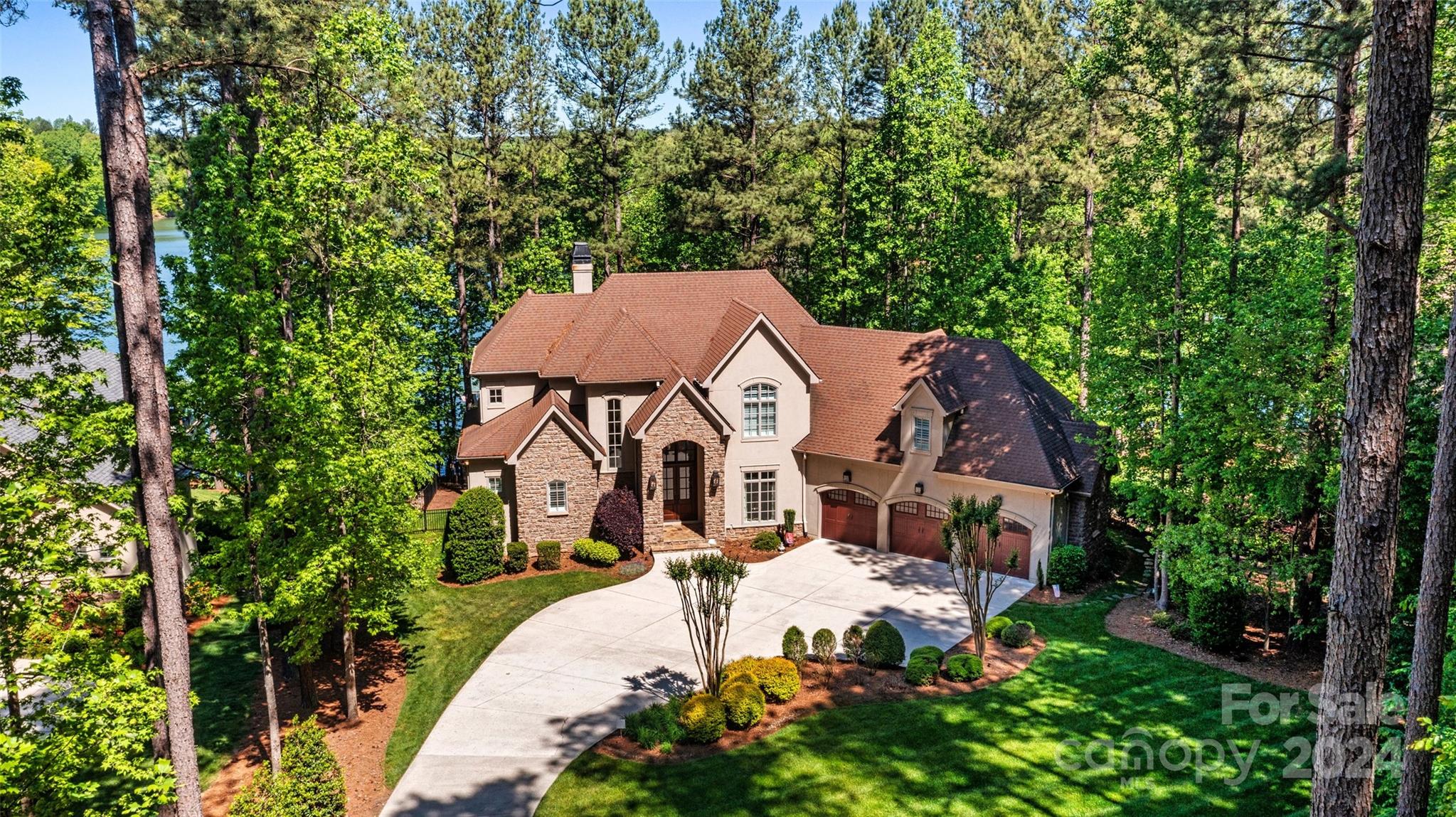 You WANT to SEE this! *Waterfront views from nearly every room in the house* Motivated sellers on this gorgeous, custom waterfront home. Boat and furnishings are negotiable also. Upon entry you are greeted with lovely hardwood floors, coffered ceilings, and a serene, picturesque view of the lake. There was truly no detail overlooked in the craftsmanship of this luxurious home. Boasting a chef's kitchen complete with high end appliances, double oven, subzero wine fridge, granite countertops, pot filler, and more. Enjoy dinner or cocktails on the screened porch with fireplace looking over the water. Flaunting 3 floors of spectacular living options you can take the elevator to top floor to find a sitting room/office, and 3 bedrooms all with ensuite bathrooms. Head down to the basement where you are sure to enjoy the wine cellar, fireplace, billiard table, exercise room, & walk out view of the water. The manicured lot is over an acre and nestled among a canopy of trees. Storage galore!!