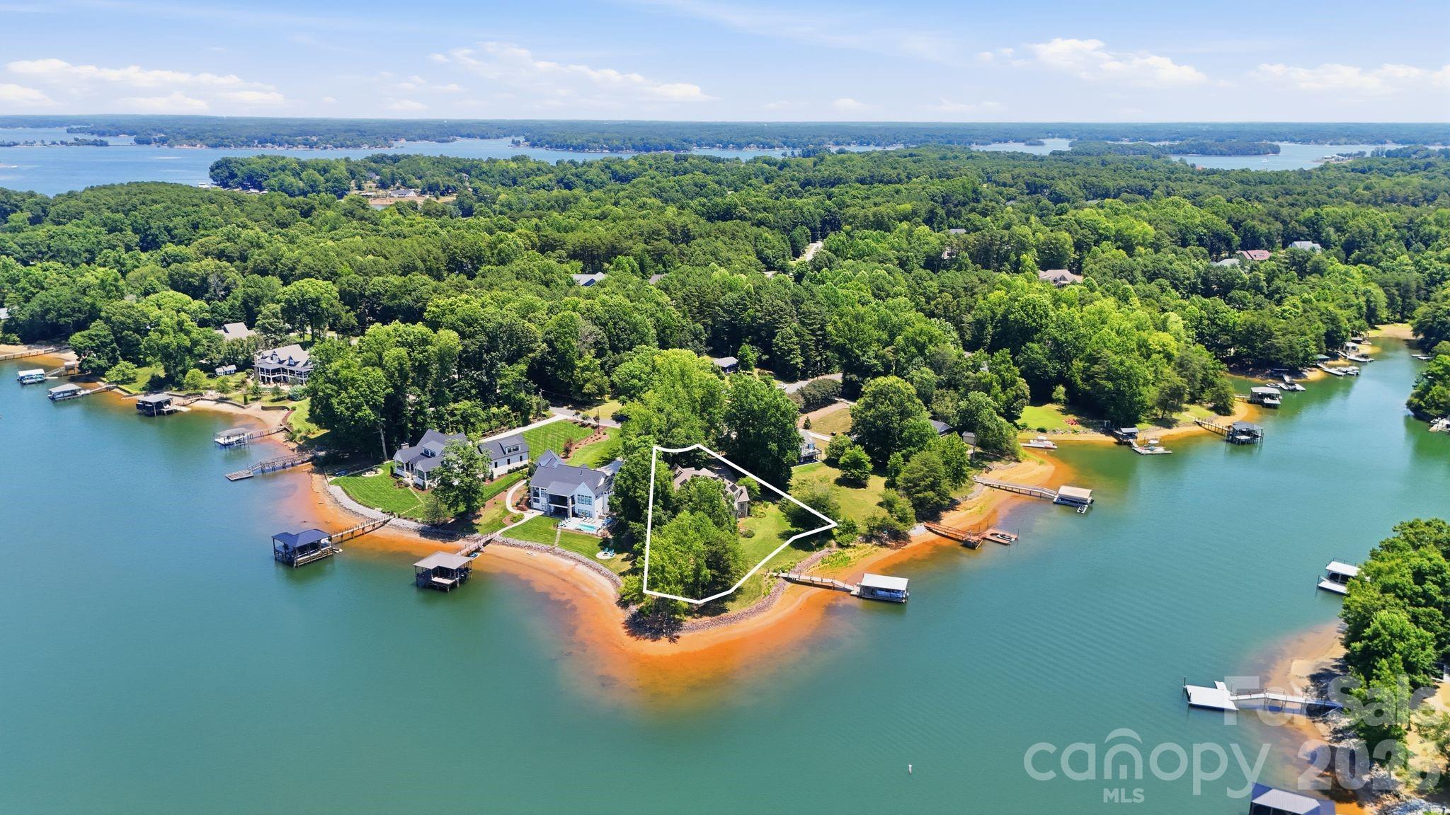 Extraordinary lakefront properties begin with extraordinary lots—and this one is truly exceptional. Positioned near the end of a point, this custom-built, one-owner home enjoys sweeping water views in nearly every direction, creating a waterfront setting that few Lake Norman properties can match. The property's unique setting and expansive shoreline create the feeling of being surrounded by water, making this a remarkable place to call home.

Offering approximately 4,600 square feet, the home was thoughtfully designed to embrace its spectacular surroundings. The dramatic two-story great room features soaring ceilings, a floor-to-ceiling fireplace, and walls of windows that keep the lake as the focal point. The open-concept kitchen, dining, and living areas create an inviting space for both everyday living and effortless entertaining.

One of the home's favorite gathering places is the breakfast area just off the kitchen. Wrapped in windows on three sides, it offers breathtaking lake views, making it the perfect place to enjoy your morning coffee or gather with family and friends.

The spacious main-level library provides the perfect home office, den, or reading room. While the home is permitted as a 3-bedroom residence, it also includes two flex rooms, an upstairs office, and an oversized bonus room complete with a wet bar featuring a sink, refrigerator, and cabinetry. The bonus room offers excellent potential as a second living area, media room, or recreation space.

Additional highlights include hardwood floors, heated floors, a traditional HVAC heat pumps, fully owned solar panels (not leased), and an energy-efficient design that offers year-round comfort. Outside, the grounds were originally designed by a Master Gardener and offer a wonderful foundation for the next owner to enjoy and personalize. A private pier and covered boat dock make it easy to enjoy boating, fishing, or simply relaxing while taking in the peaceful lake setting.

Nestled in a small, tranquil waterfront neighborhood with no HOA, the home also offers exceptional convenience. Enjoy easy access to Highway 16, making commuting to Charlotte and the airport simple. Dining, shopping, golf, Birkdale Village, Huntersville, Mooresville, and Hickory are all within easy reach.

A special Lake Norman home—and a wonderful place to call home.