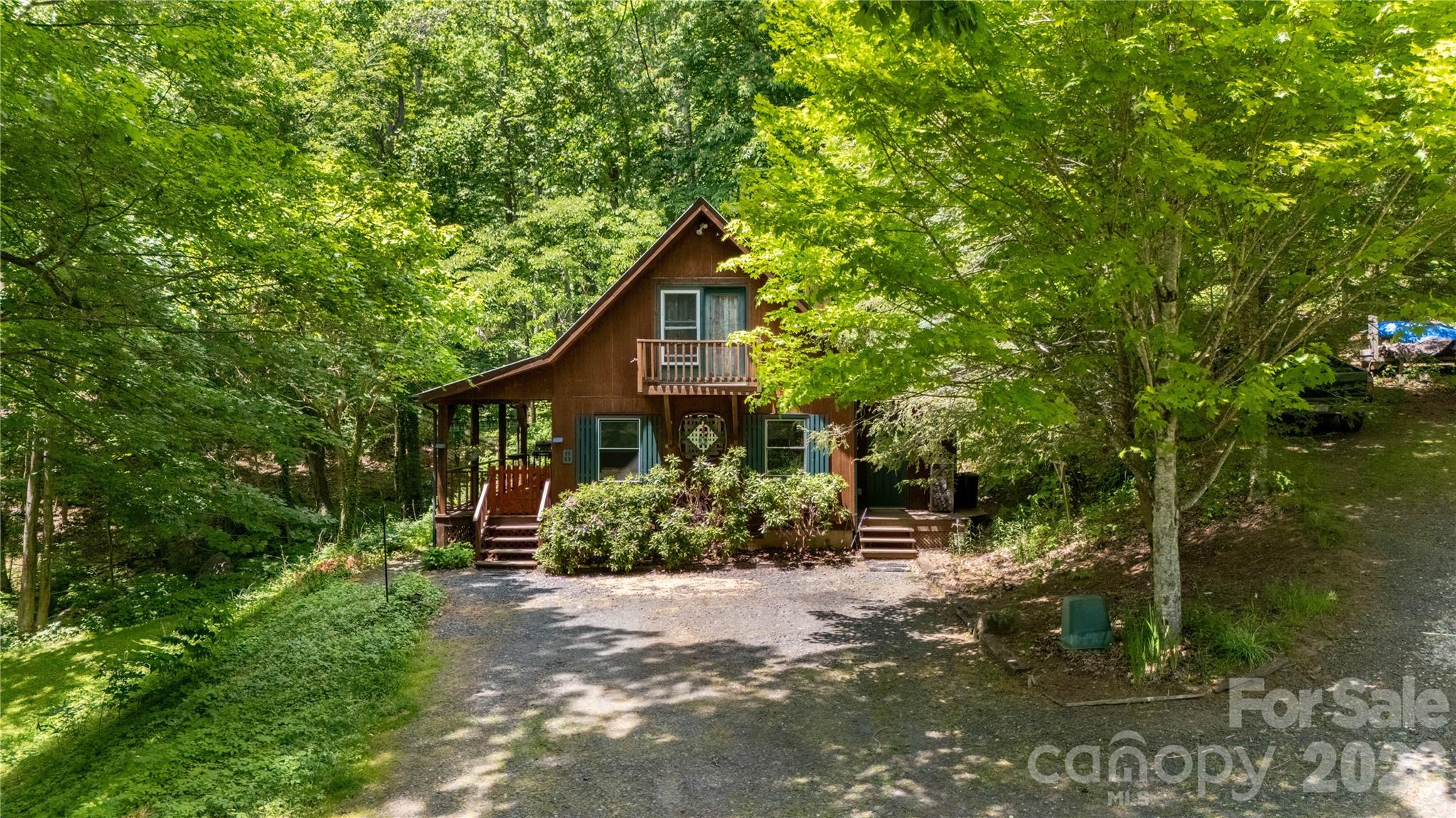 Tucked away at the end of the road in the Blue Ridge Mountains, this charming mountain retreat offers the privacy and peaceful setting so many buyers are searching for. Surrounded by mature trees and natural beauty, the property feels like your own secluded getaway while still providing comfortable everyday living.

The home features classic cabin character with warm wood siding, covered porch space, and multiple outdoor areas to relax and enjoy the sights and sounds of nature. A private upper balcony adds even more charm and creates the perfect spot for morning coffee or unwinding in the evenings.

Inside, you’ll find a cozy and functional layout with an open living area, abundant natural light, and a wood stove that adds warmth and mountain cabin appeal. The kitchen offers ample cabinet and countertop space along with a center island perfect for casual dining, meal prep, or gathering with family and friends. The inviting interior creates a comfortable atmosphere ideal for full-time living, weekend escapes, or a vacation rental opportunity.

The property itself is what truly sets this home apart. Wooded surroundings, unique rock features, and a small pond create a peaceful outdoor setting that feels private and relaxing year-round. Whether you enjoy gardening, exploring nature, entertaining outdoors, or simply sitting on the porch listening to the sounds of the woods, this property offers endless possibilities.
Outside theres a garage/workshop with power to handle any extra storage or hobbies you desire.
With its private location, usable acreage, cabin charm, and serene natural surroundings, this mountain property offers the perfect blend of comfort, character, and seclusion. Must be accompanied by a licensed NC real estate agent for all showings. No same day showings please, the seller would like time to tidy up so please plan ahead!
