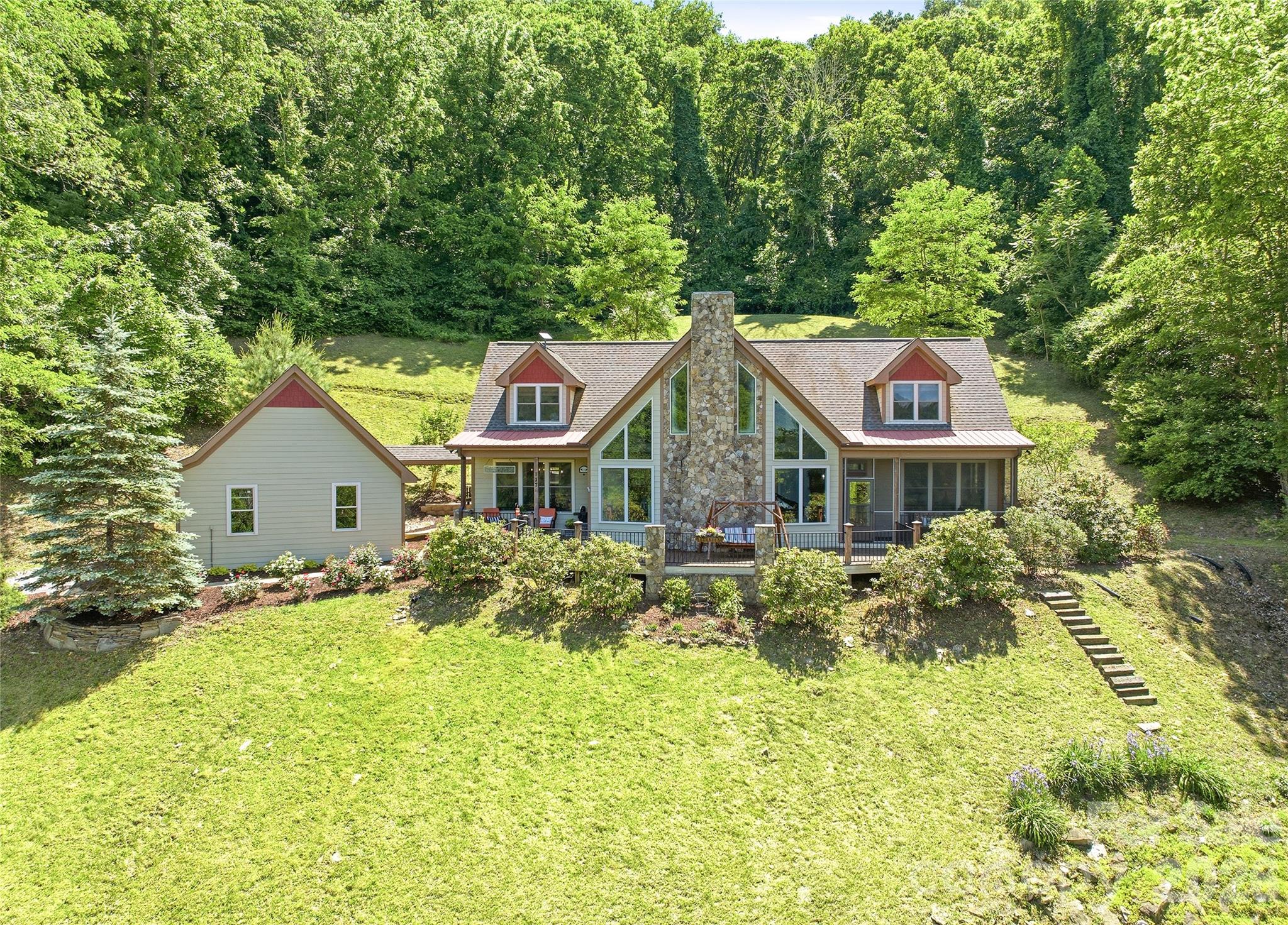 Enjoy year-round, long-range mountain views from this inviting home in Mars Hill, in the sought-after Traditions Way community, known for its peaceful mountain setting, well-maintained homes and welcoming atmosphere. Residents enjoy community scenic ponds, a clubhouse and beautifully maintained common areas, all surrounded by the natural beauty of Western North Carolina. Conveniently just minutes from downtown Mars Hill and a short drive to Asheville, Traditions Way offers a balance of privacy, convenience and mountain living. The main level features hardwood floors in the primary living areas, fresh interior paint, a dedicated office space with high speed internet available and a cozy gas fireplace. The spacious primary suite includes a private bath with jetted tub and a screened porch positioned to capture mountain views. Quartz countertops enhance the kitchen, primary bath and powder room. Upstairs, a loft provides flexible living space, along with two guest bedrooms, each featuring its private bath. The intimate backyard offers a peaceful retreat with a stone patio and walkway, ideal for relaxing or entertaining. Additional highlights include a full-house generator and a detached garage connected by a covered breezeway, with pull-down stairs leading to abundant overhead storage.  With its combination of scenic beauty, community amenities and easy access to dining, shopping, outdoor recreation and area universities, this home offers an exceptional mountain lifestyle in one of Mars Hill’s desirable communities.