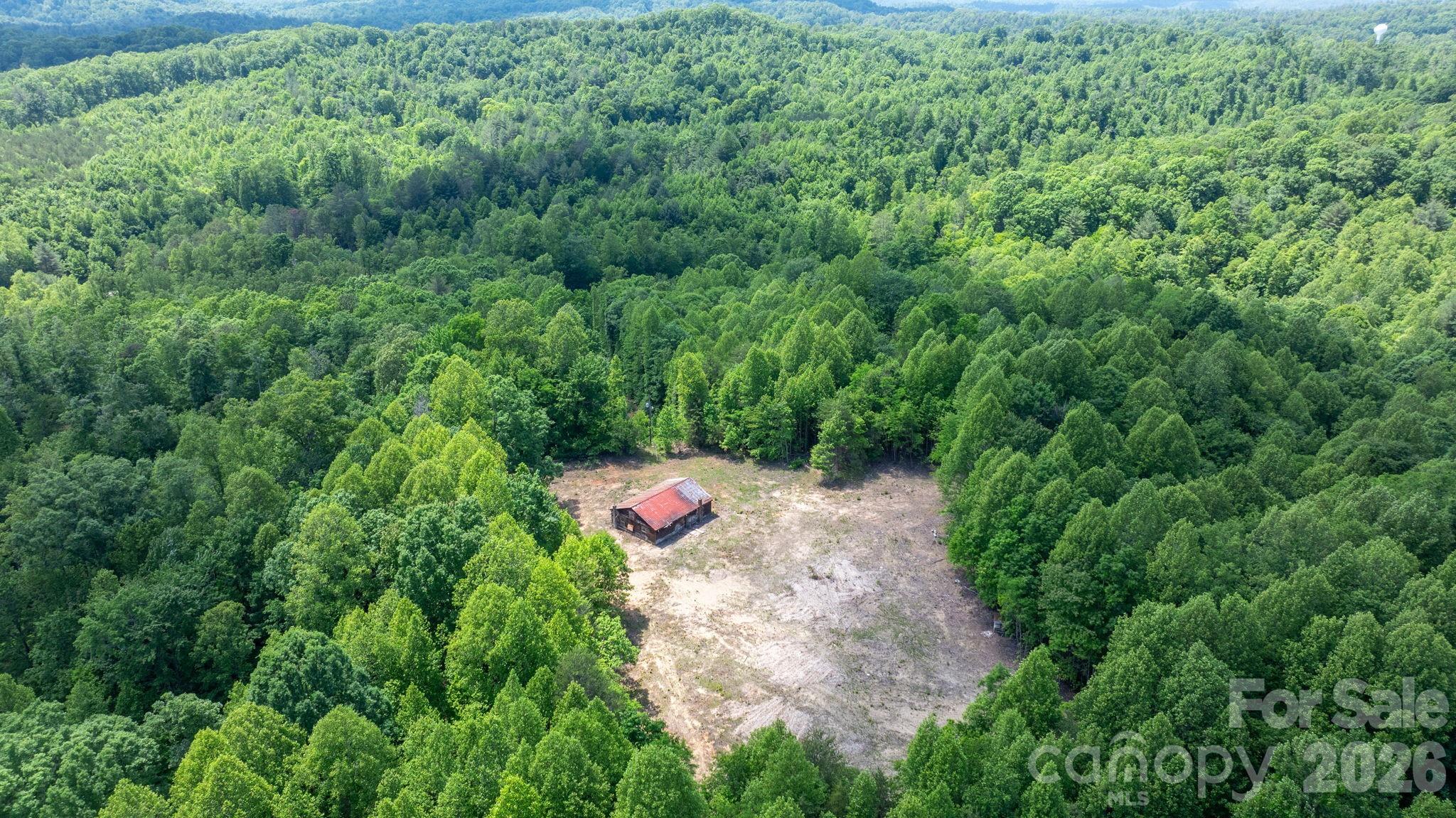 Discover the potential of this beautiful 23-acre property at 1460 Husbands Creek Rd in Lenoir, NC. Offering privacy, natural beauty, and multiple building opportunities, this tract features two existing homesites already in place. One homesite sits at a higher elevation with the potential for long-range mountain views and includes approximately one acre already cleared and ready for your vision.  

Whether you're looking to build a private mountain retreat, family estate, or investment property, this land offers the flexibility and space to make it happen. Enjoy the peaceful setting, abundant wildlife, and the convenience of being just a short drive from downtown Lenoir while still feeling tucked away in the countryside.

A dirt road already exists to reach the upper portion of the property. I would suggest only attempting this ascend with a 4x4 vehicle at your own risk(I was able to make the climb in 2-Wheel drive with an older truck). There are survey stakes with pink ribbon marking the path up to the cleared acre on the mountain and the walkable-path up to the highest peak on the property. 

There is currently a home at the entrance to the property that will most likely need to be torn down or at least be professionally treated for mold. The second building up on the cleared portion of the property is also not safe for access but may be easier to recover than the house! Both Buildings have septic systems installed and wells providing water but the owners are unsure of the condition of the systems.