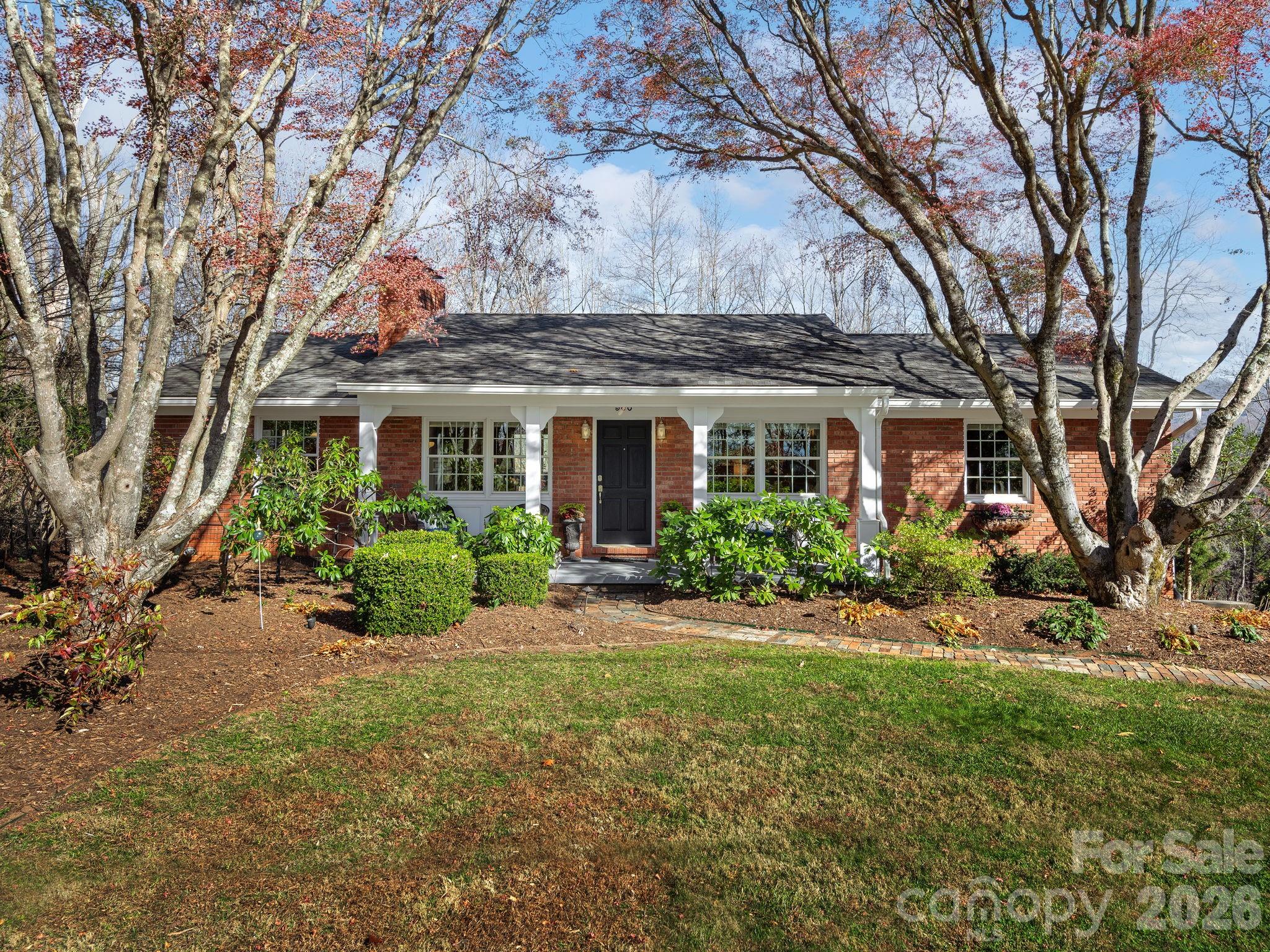 As you enter this beautifully maintained and updated brick home, you will be charmed by its character. Uniquely located in the desirable Grove Park area, this home offers you year-round stunning mountain views. Living room includes a wood burning fireplace and additional seating area for entertaining. The kitchen is bright with custom crafted wood cabinetry and newer appliances. The dining area offers a second wood burning fireplace with built-in storage. Primary bedroom with ensuite bath,  two guest bedrooms and full bath are all on the main level. Relax and enjoy the beautiful views from the spacious upper and lower decks. Finished basement area provides the perfect space for media room, guest room, or family room. Garage entry leads into the laundry/mud room. Home is equipped with plenty of storage closets and space. This lovely home is a gem in the Grove Park community!