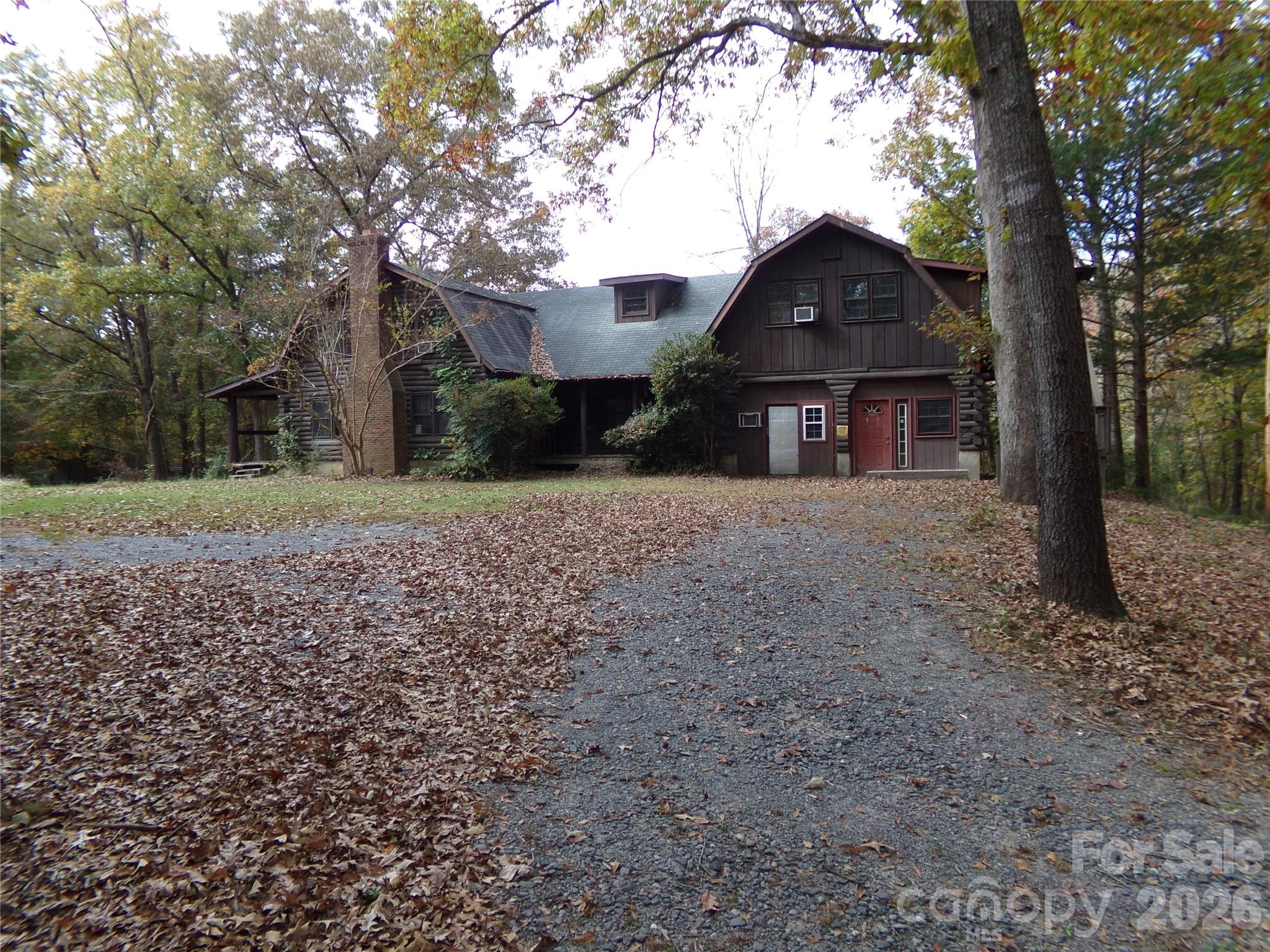 Back on market with an extra Manufacture Home and 1/2 acre homesite.  Large Log Home on 7.38+/- Acres with nice pond.  Property has metal shop, carports, storage sheds and two old mobile homes (Not Livable).  Pond has small island ideal for waterfowl.  Land is already in 5 tax maps being offered altogether.  Home is being sold "as is".  Great for small farm or family compound near the conveniences of Indian Land SC & Charlotte NC.  Great opportunity for developer or builder.