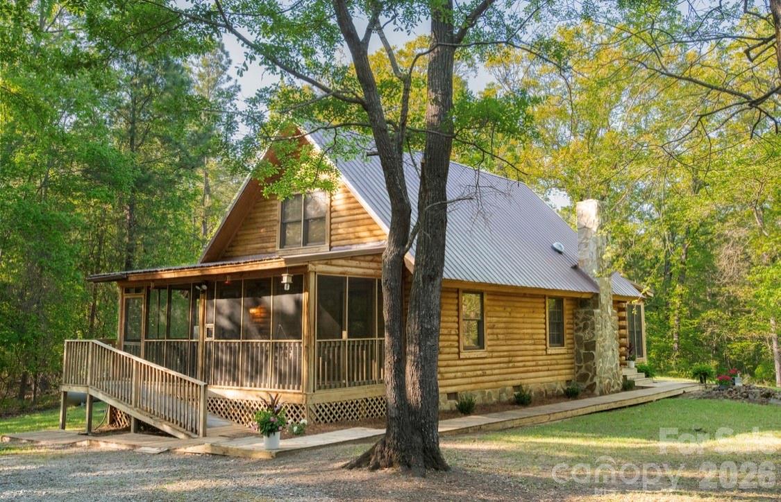If you've been looking for your "little cabin in the woods", this is it. A gorgeous custom log home on a 1.5 acre parcel offers you privacy surrounded by nature and access to beautiful Lake Wateree! Once you enter the gated entrance, this home sits beside a private waterfront access area that you share with just a few of your surrounding neighbors. The custom log home features vaulted tongue in groove ceilings, lots of windows, wood floors and a gas fireplace. A tankless gas water heater and new 3 ton gaspac were installed in 2019. The floor plan is flexible with a master downstairs and a flex room/sun porch on the other end of the home. This room was previously used as a 3rd bedroom so previous owners installed a walk in closet and half bath. There is also a loft bedroom upstairs that could also be an office. The private lake access has a covered picnic shelter, aluminum benches, private dock and swim area. From Memorial to Labor day, there is a port-a-john installed that is cleaned weekly. Extras include a heated and cooled workshop, shed, and carport or boat cover. Sit on the screened porch and listen to the birds or walk down to the dock at the private waterfront park. So peaceful and private! You'll feel like you're sitting on a mountaintop. It's the best of both worlds!