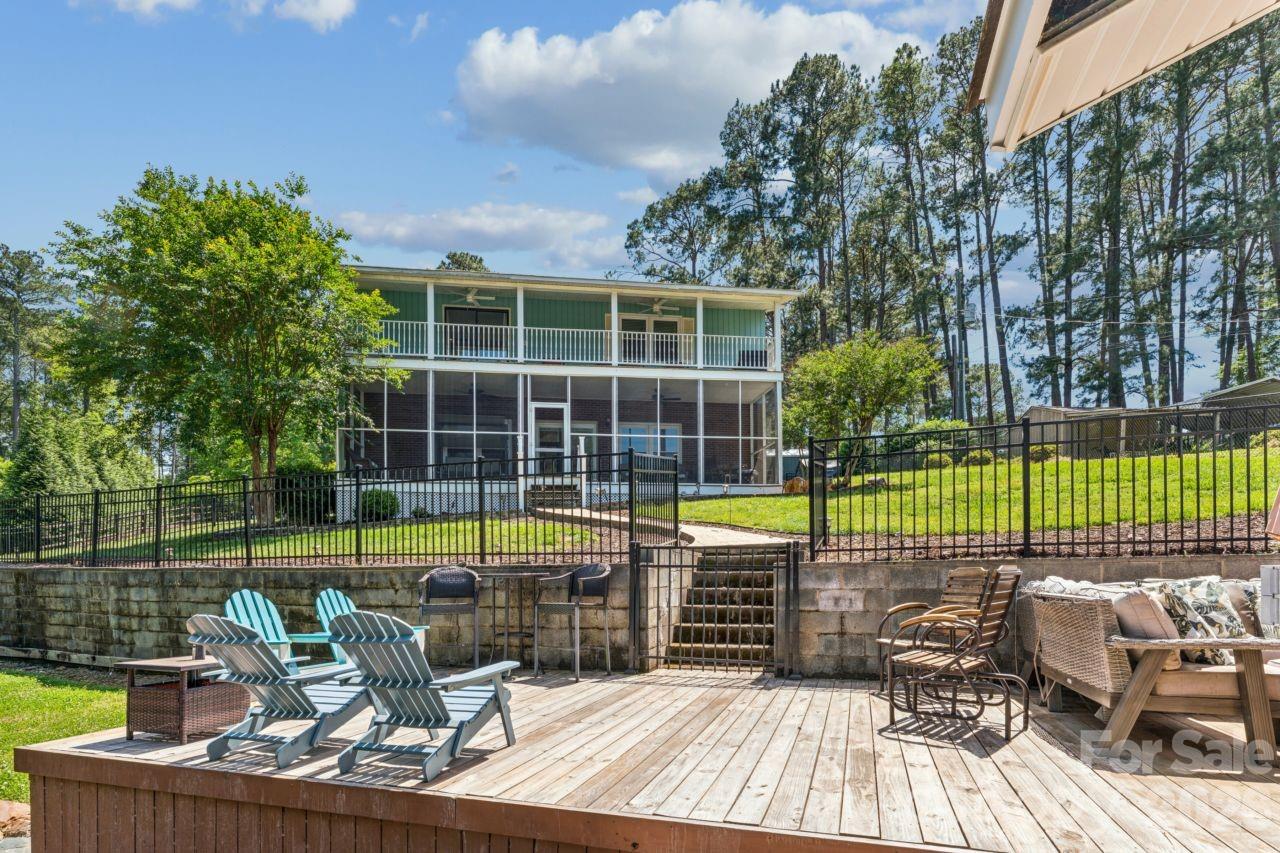 PRICE REDUCED!! Beautiful Lake Tillery home located in a peaceful cove on a double lot. It features a covered double boathouse with lifts, two jet-ski docks, a large storage room, and a large dock on the water to enjoy entertaining friends.  The home offers 3 bedrooms and 2 full baths on the main and upper levels.  The lower level has a den and a large bonus room currently used as a bedroom.  A screened porch is located on the lower level leading to the boathouse. There is a private balcony off the primary bedroom on the upper level.  Primary has spacious en suite bathroom featuring a large tiled walk-in shower with glass enclosure.  Double sink/vanity area with storage. Natural light filters through the transom window above, and there's generous floor space beneath for a freestanding tub. Install a freestanding tub and enjoy a soaking nook.  An open dining area flows between kitchen and family room which includes stone fireplace with gas logs. Kitchen has granite countertops, newly painted cabinets and stainless steel appliances to convey. Plenty of space inside and out for family and friends! House has central vacuum. Washer/dryer to convey. Home warranty is included.(*All outside furniture stays with home. Indoor furniture can be negotiated dependent on offer.)
