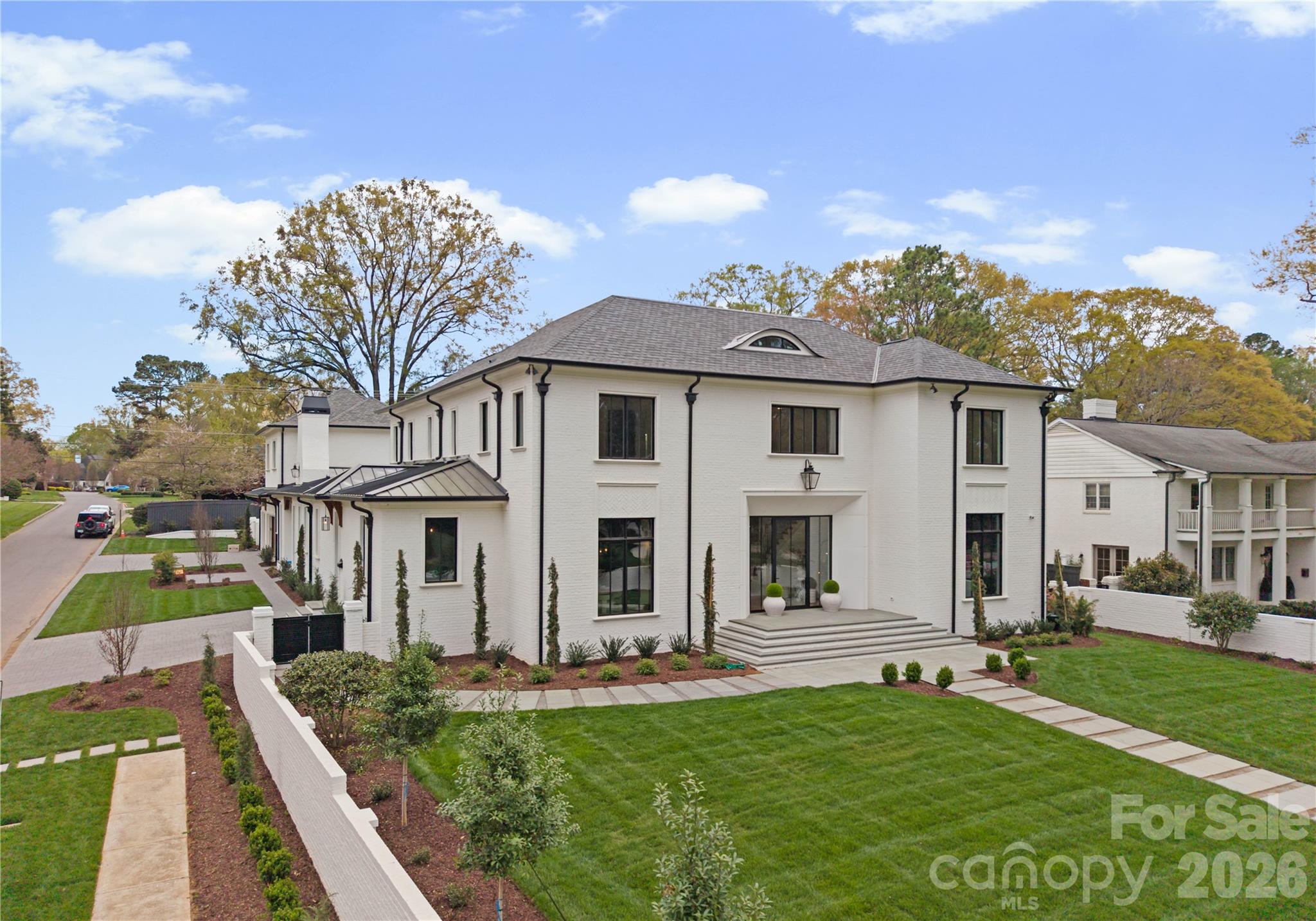 Experience an extraordinary level of luxury in the heart of Charlotte with this architectural showpiece, set on 0.53 acres and designed to impress at every turn. This full-brick, multi-generational estate features designer fiberglass shingles paired with a striking metal roof and offers an impressive 8,553 heated sq ft, including a private 776 sq ft guest/in-law/teen residence. A rare offering, the property showcases two architecturally distinct homes seamlessly blended for elevated living and grand-scale entertaining.

From the moment you arrive, every detail reflects intentional design and superior craftsmanship. A dramatic 10’ x 5’ glass and metal entry door welcomes you into 2 story tall foyer with a magnificent chandelier. The foyer offers the convenience of an elevator, and the interiors are defined by 12’ soaring ceilings, 10’ ceilings upstairs, and 10’ interior doors throughout. Rich 5” white oak hardwood floors flow seamlessly, while 4 linear gas fireplaces and 2 dual-fuel Isokern fireplaces create warmth and architectural drama. 
The heart of the home is a true culinary masterpiece—featuring dual waterfall quartzite islands surrounded by soft-close cabinets and drawers, spice racks, premium appliances, an extraordinary custom-built and designed hood, and an effortless flow into the breakfast and family room, making the home a soul. A fully appointed scullery kitchen with a coffee station elevates hosting to a professional level. The formal dining room, complete with a designer wet bar and glass-front wine display, sets the stage for unforgettable gatherings.
Thoughtfully designed for modern luxury living, the home features a beautifully appointed mudroom with custom built-ins, workspace, and an integrated steamer in the laundry area. Expansive windows flood the home with natural light, accentuating tall ceilings and statement lighting throughout. A flex/bedroom/study room with an electric fireplace on the main level.
The primary suite is a private sanctuary rivaling a five-star resort, featuring a spa-inspired bath wrapped in marble, a statement chandelier over the soaking tub, a seamless walk-in shower with spa-grade shower system, and an exceptional custom closet designed to showcase and organize a luxury wardrobe.

Upstairs, 4 spacious en-suite bedrooms and a loft with a wet bar provide both privacy and refined comfort for family and guests. Multiple laundry areas, including a dedicated guest suite laundry, ensure effortless daily living.
Step outside into your own private resort—where every detail is designed for elevated living and effortless entertaining. A heated saltwater pool and spa create a serene focal point, complemented by a fire pit and an expansive covered patio featuring a gas fireplace and a wet bar with counter space. This is indoor-outdoor living at its absolute finest.

 A dedicated wellness retreat offers a true at-home spa experience. Thoughtfully designed with custom cabinetry, a beverage station and ample counter space for your Vitamix, the space flows seamlessly into a private gym and yoga studio. A dry sauna, steam shower, and full bath complete this tranquil escape—bringing daily rejuvenation right to your doorstep.


The full brick fenced wall around the grounds, with an irrigation system are equally impressive, featuring four custom metal louvered gates, cedar herringbone garage doors, energy-efficient metal exterior doors with digital locks, and a comprehensive surveillance system. Professionally designed landscaping, a unique concrete-designed driveway, and a striking wall fountain on the side complete the estate’s commanding presence.

This is more than a home—it is a statement of lifestyle, design, and distinction.