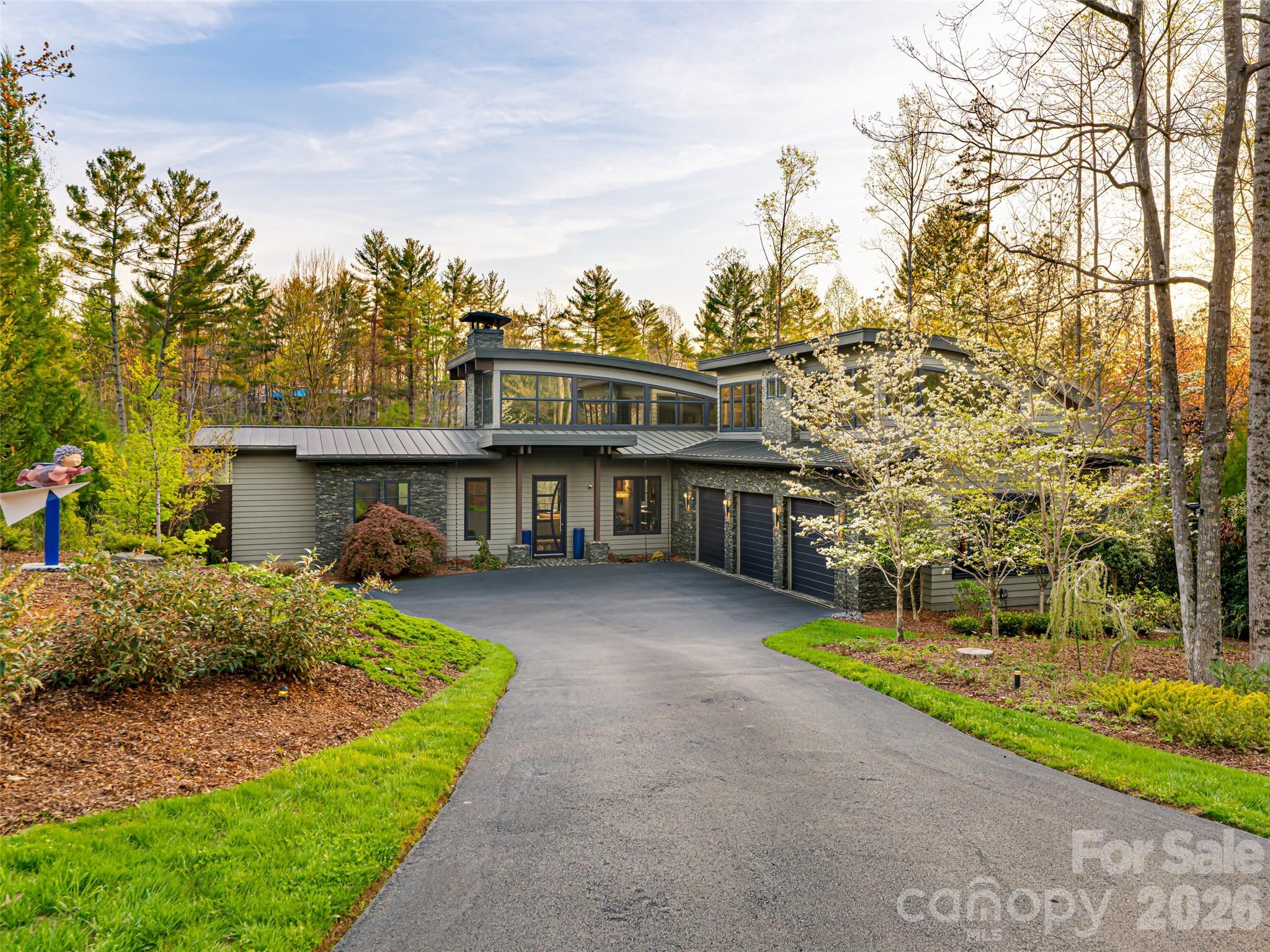 Nestled on a verdant 0.82-acre parcel within Asheville's highly coveted, gated Ramble Biltmore Forest, 32 Brookline Drive is an exceptional contemporary estate spanning 5,073 square feet. This 4-bedroom, 4.5-bathroom architectural triumph seamlessly weds inviting warmth with modern sophistication. Upon entry, the home makes a striking impression with its towering ceilings, expansive glass walls that flood the interior with natural light, and a breathtaking floor-to-ceiling sculptural marble fireplace, all grounded by the rich contrast of ebonized bamboo flooring. The chef-inspired, open-concept kitchen balances aesthetic brilliance with pure functionality. At its heart is a spacious island illuminated by three exquisite Murano glass globes. It is fully outfitted with a new 48-inch Fulgor Milano Sofia range, striking Brazilian granite adorning the counters and backsplash, and extensive custom cabinetry featuring reinforced drawers specifically designed for heavy cast iron and Le Creuset cookware. A thoughtfully designed butler’s pantry enhances the space with a second refrigerator and discreet under-cabinet angle power strips. Located on the main level, the luxurious primary suite functions as a private retreat. Its spa-like en-suite bathroom boasts radiant-heated floors and dual Kohler shower systems complete with a rain showerhead, while the custom walk-in closet offers extensive floor-to-ceiling organization. Step outside the suite to discover a private, fenced-in terrace surfaced with synthetic turf—perfect for sunbathing or providing a secure play area for pets. Upstairs, a dedicated guest wing features its own private entrance, three spacious rooms, and a convenient kitchenette, making it an ideal setup for long-term visitors.

Modern convenience and cutting-edge technology are woven throughout the property's design. The oversized three-car garage is equipped with updated 2024 openers and pre-wired for dual EV charging stations. Behind the scenes, the home operates flawlessly with an Eaton whole-house generator, a new 2024 five-zone HVAC system, Trane XR air filtration and humidification, and two tankless water heaters featuring recirculation. A designated wine room equipped with a wine keeper awaits your finishing enclosure. For the tech-savvy, AT&T high-speed fiber, a monitored security system, and comprehensive Control4 and Lutron automation manage the home's lighting and 14 dedicated audio zones. Embracing a seamless indoor-outdoor lifestyle, a Phantom-screened porch with a cozy fireplace flows into a meticulously landscaped pool area. The alfresco kitchen is an entertainer's dream, featuring an Earth Stone 90 wood-or-gas pizza oven and a premium Fire Magic Echelon grill with a rotisserie and infrared sear. A separate irrigation meter, remote-controlled multi-zone sprinklers, and a soothing hot tub elevate this backyard oasis. Ownership in The Ramble affords access to a premier suite of lifestyle amenities. The centerpiece is the 9,000-square-foot Living Well Center, housing a fitness facility, heated saline pool, pickleball courts, and a grand gathering room showcasing curated art and a stone fireplace. Residents can enjoy community events, card games, and book clubs at the historic Buck Spring Cabin, a remnant of George Vanderbilt’s rustic estate. Nearby, Longmeadow Park serves as the community's backyard, offering a natural amphitheater, an open-air pavilion, formal English gardens, a playground, a multi-purpose field, a basketball court, and a hand-hewn stone firepit. Framed by Overlook and Crescent Parks, alongside more than seven miles of tranquil wooded trails, this estate delivers not just a phenomenal residence, but an unparalleled living experience.